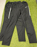 Pair of Nike black tracksuit bottoms with elastic waist and side zippered legs on grass