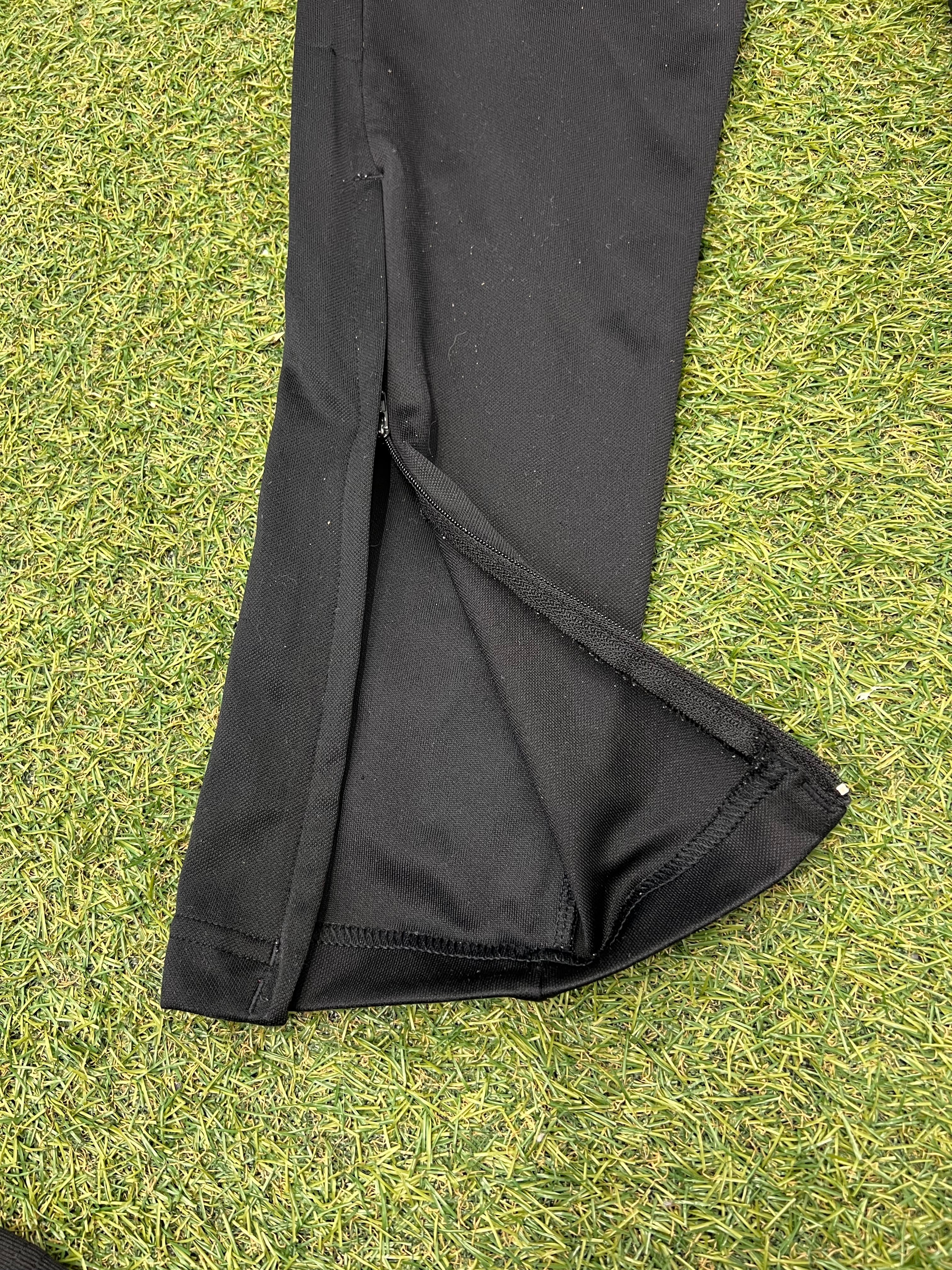 Label on Adidas tracksuit bottom showing size UK M, US M, made in Philippines with Climalite fabric tag