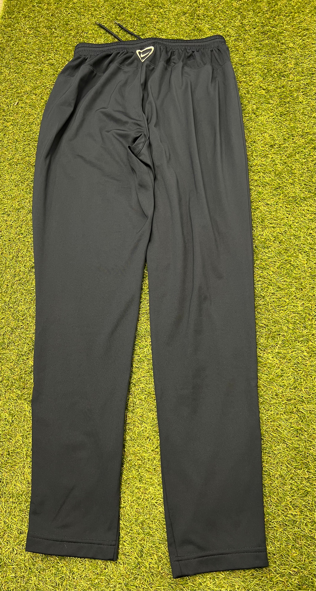 Close-up of ankle zipper detail on black Nike tracksuit bottoms
