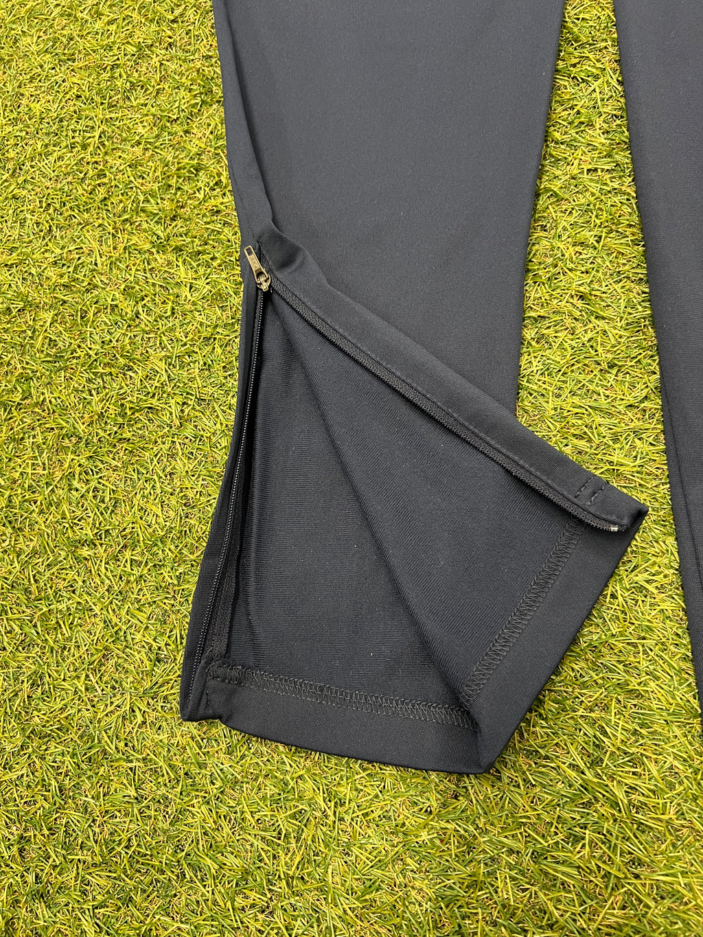 Tag inside navy Nike Dri-FIT tracksuit bottoms showing size medium and care information