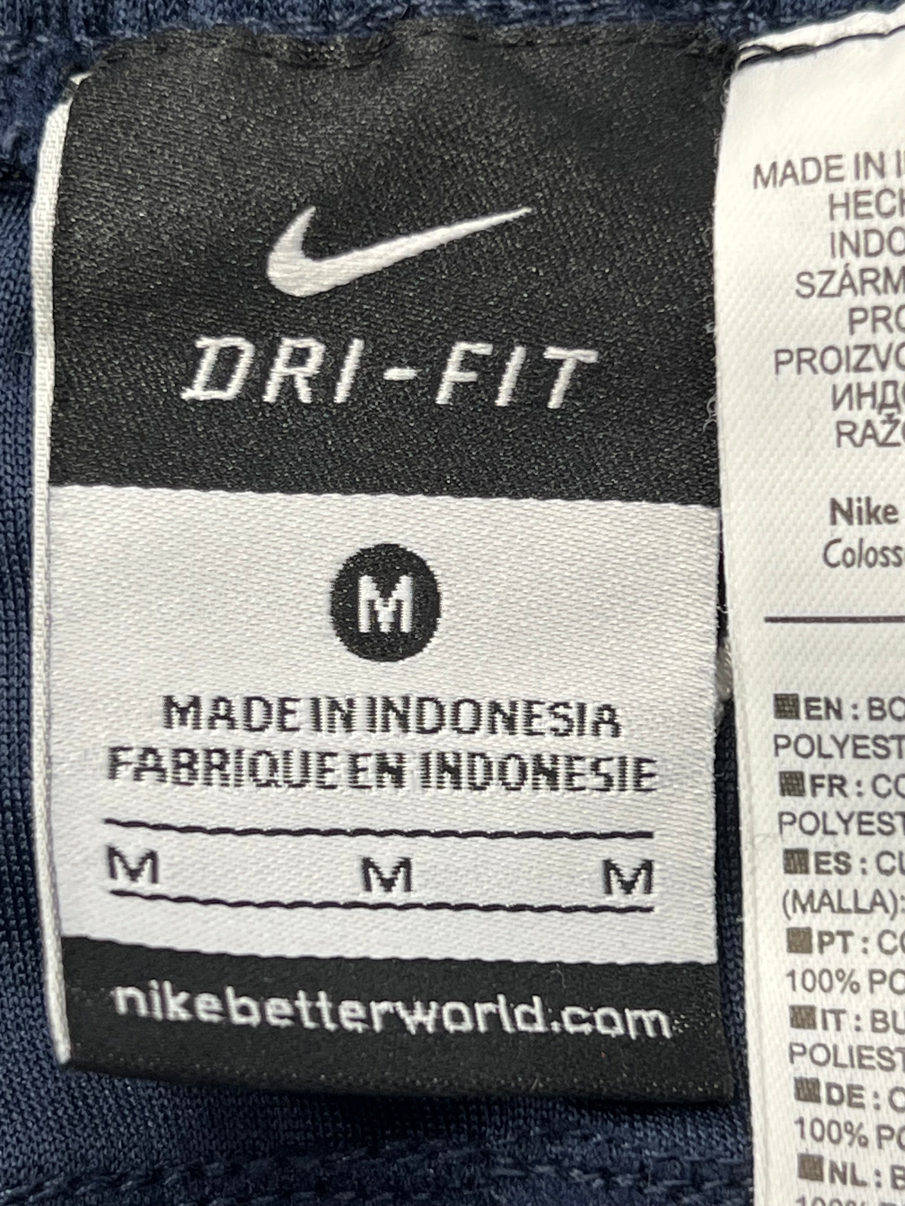 Back view of black Nike Dri-FIT tracksuit bottoms featuring mesh paneling for breathability