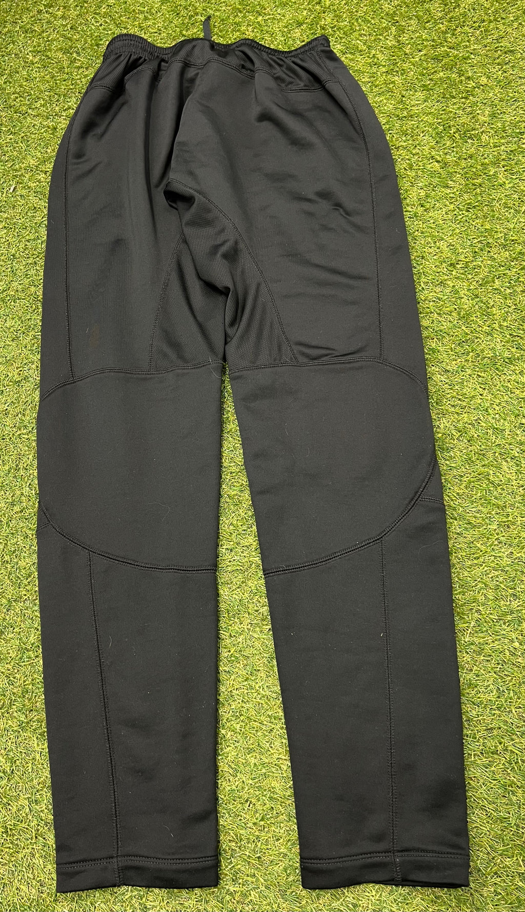 Tag inside black Nike Dri-FIT tracksuit bottoms with size and manufacturing details