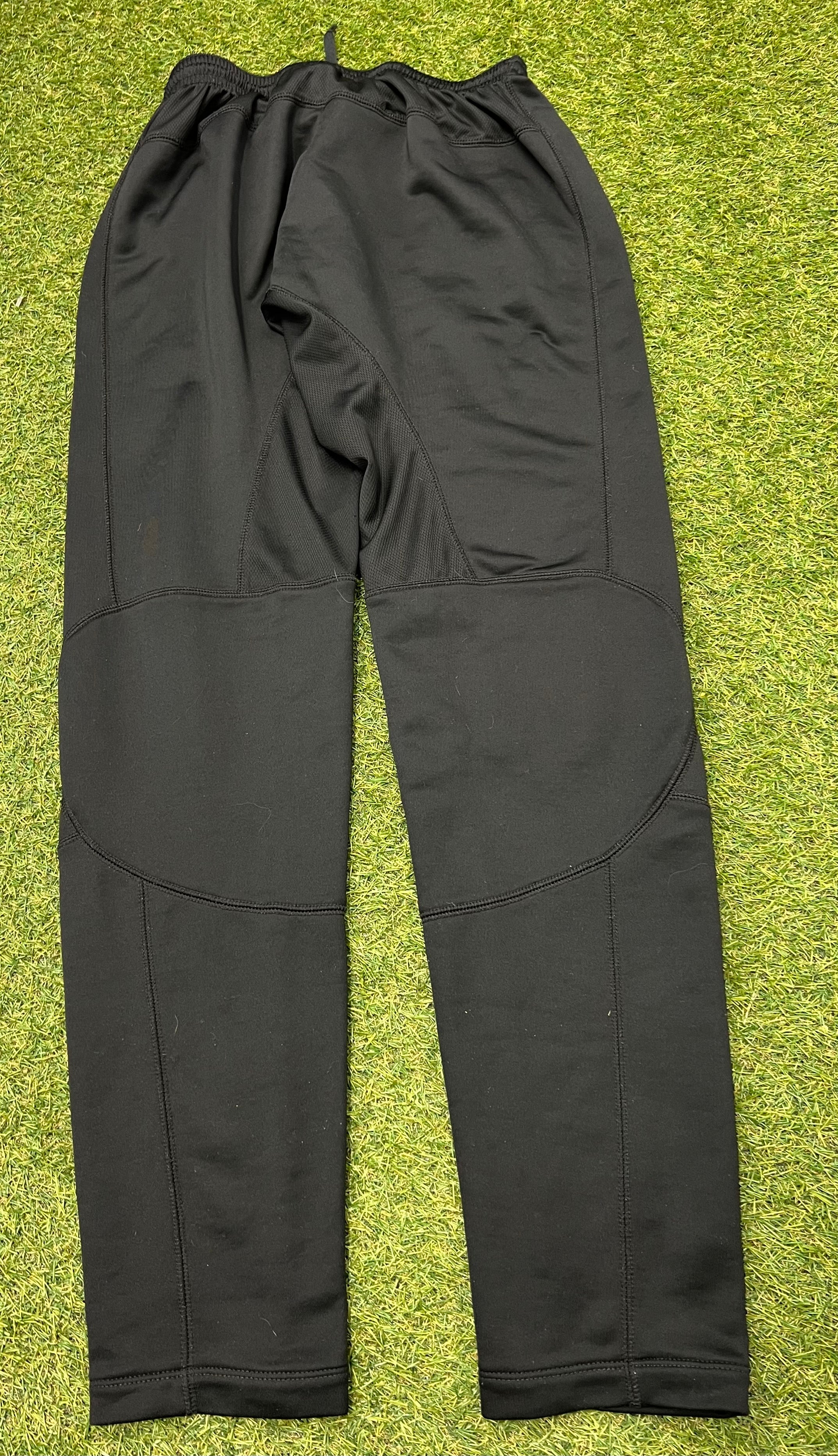 Tag inside black Nike Dri-FIT tracksuit bottoms with size and manufacturing details