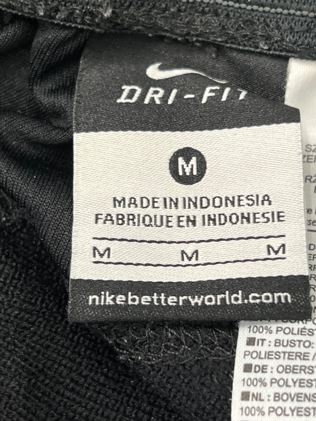 Front view of black Nike Dri-FIT tracksuit bottoms showing logo branding and elastic waistband