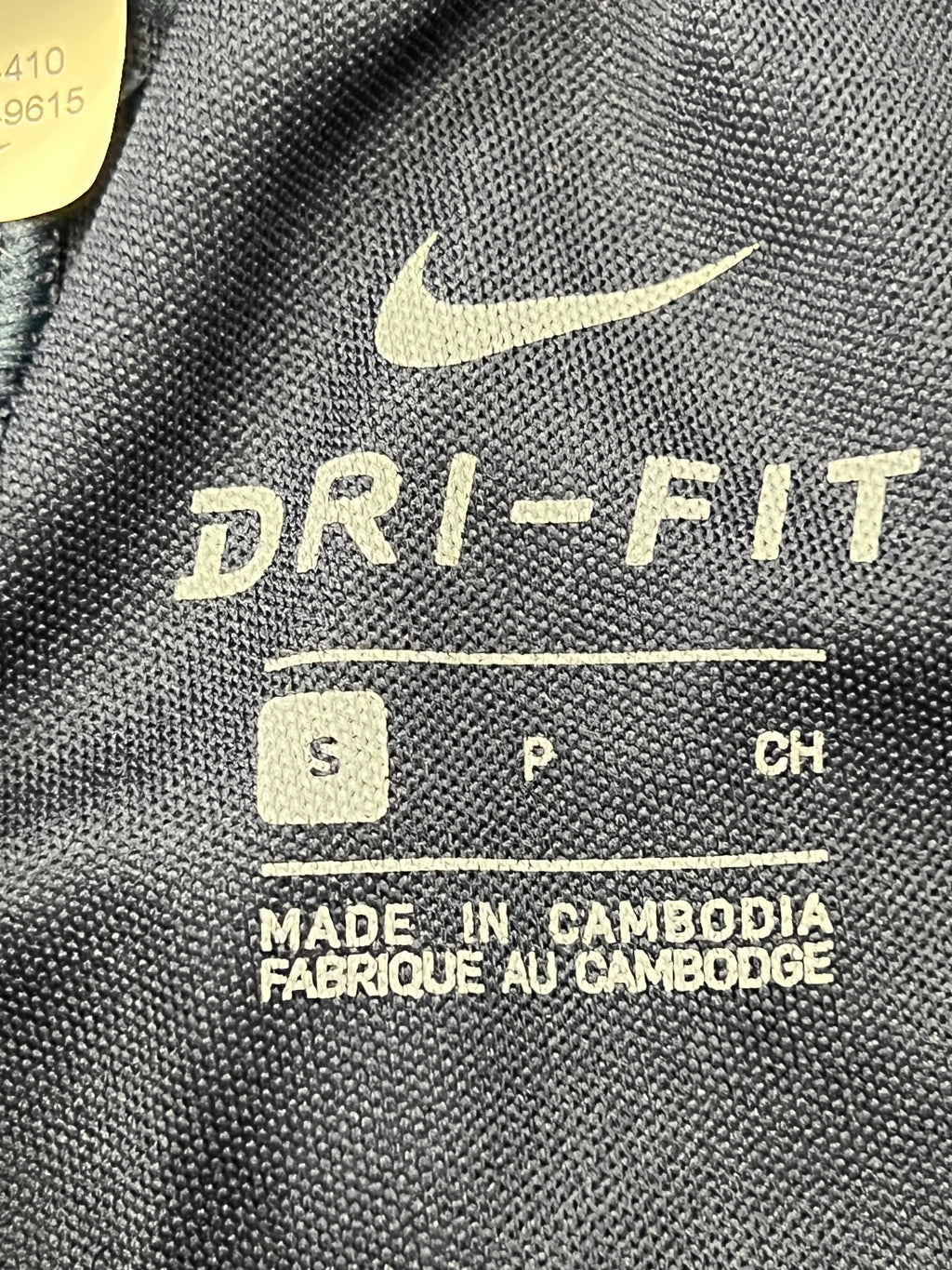 Close-up of black Nike tracksuit bottoms ankle zipper opened, showing interior lining