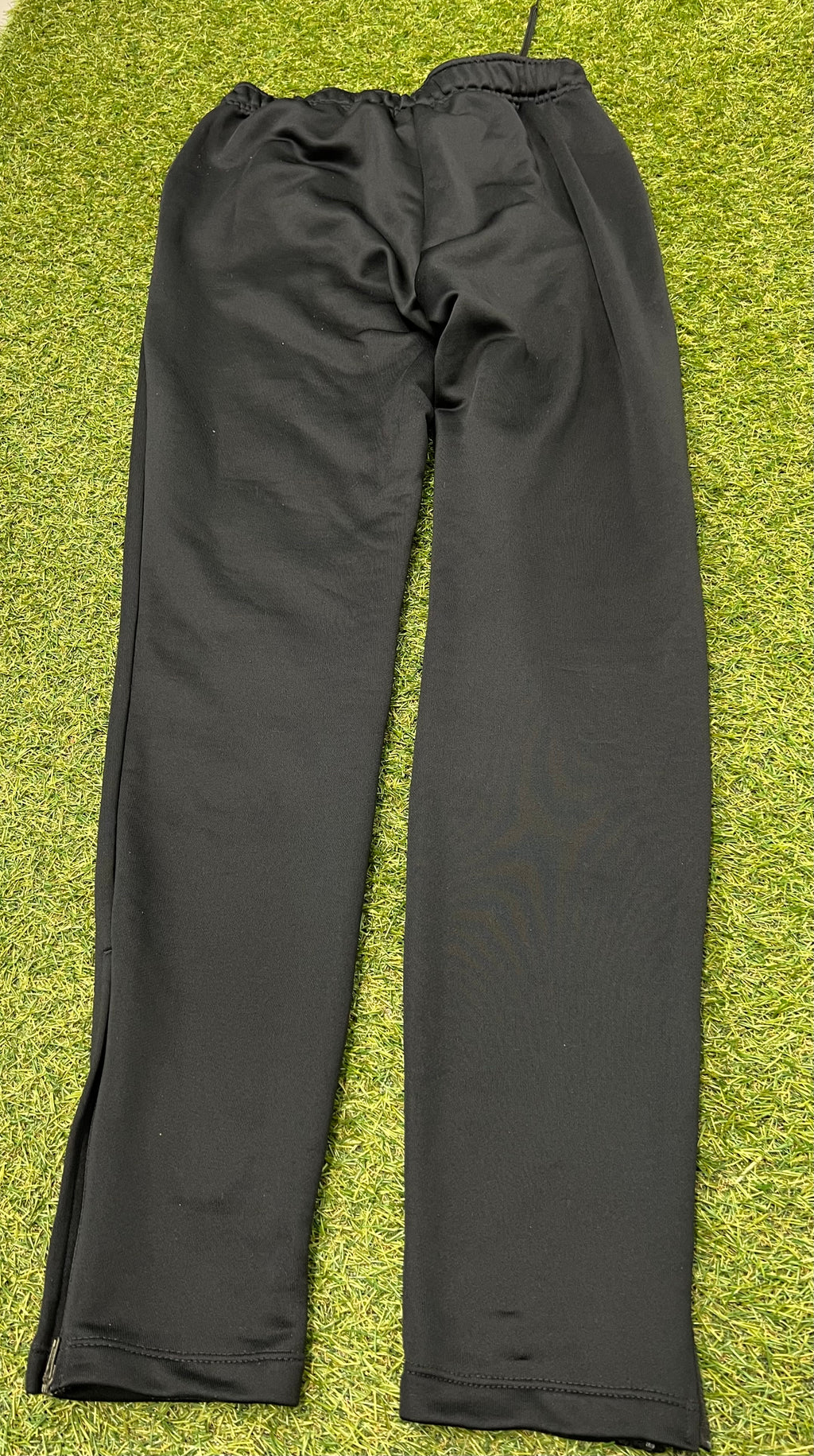 Close-up of Nike Dri-FIT logo and size label inside black tracksuit bottoms