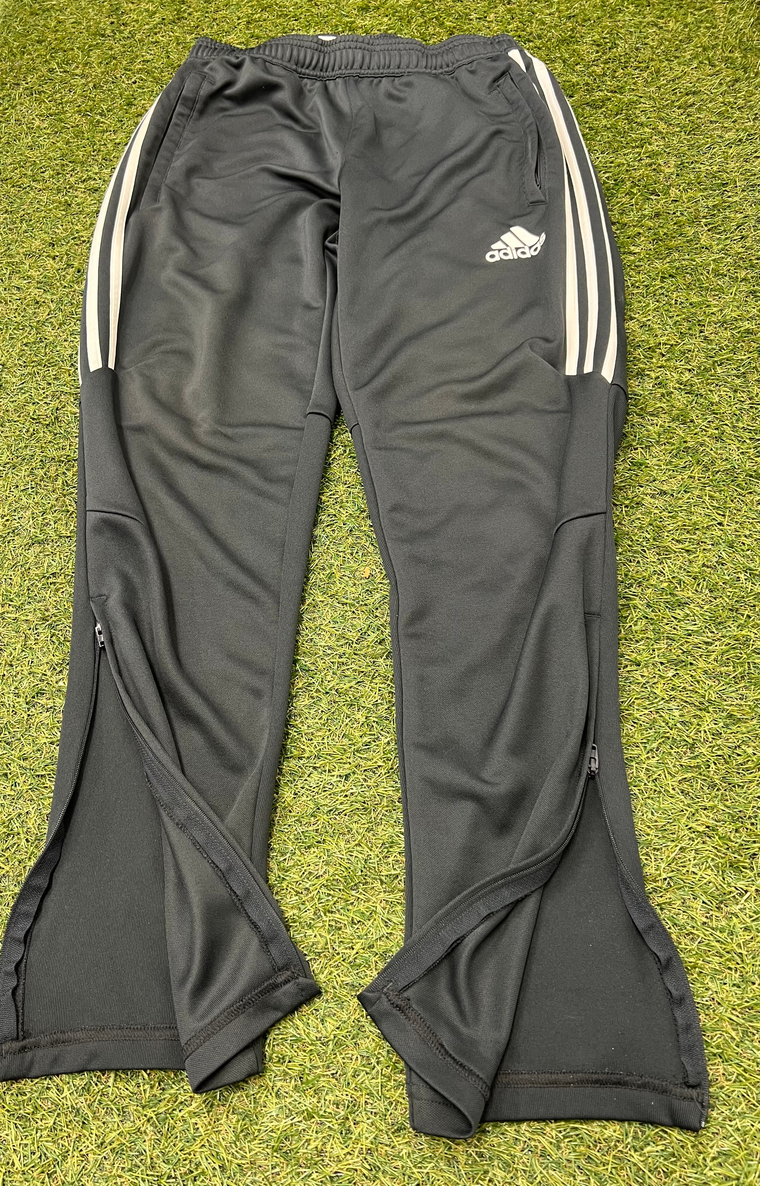 Detailed close-up of Adidas Climacool tracksuit bottoms front with zippers partly opened at ankles and white brand logo