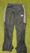adidas black tracksuit bottoms with white stripes and partial zip opening on grass