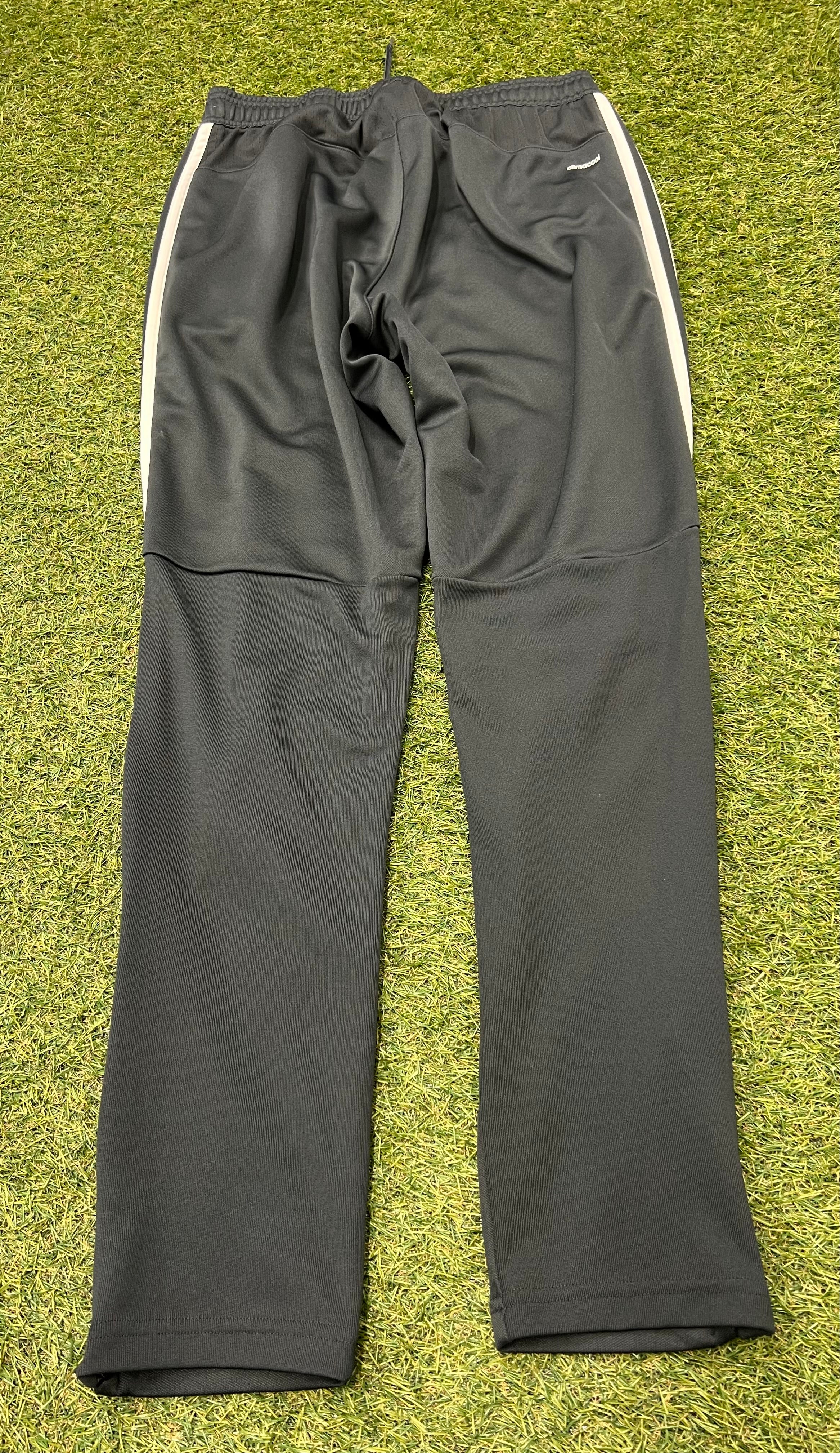 Back view of Adidas Climacool black tracksuit bottoms showing the plain rear design and elastic waistband on grass surface