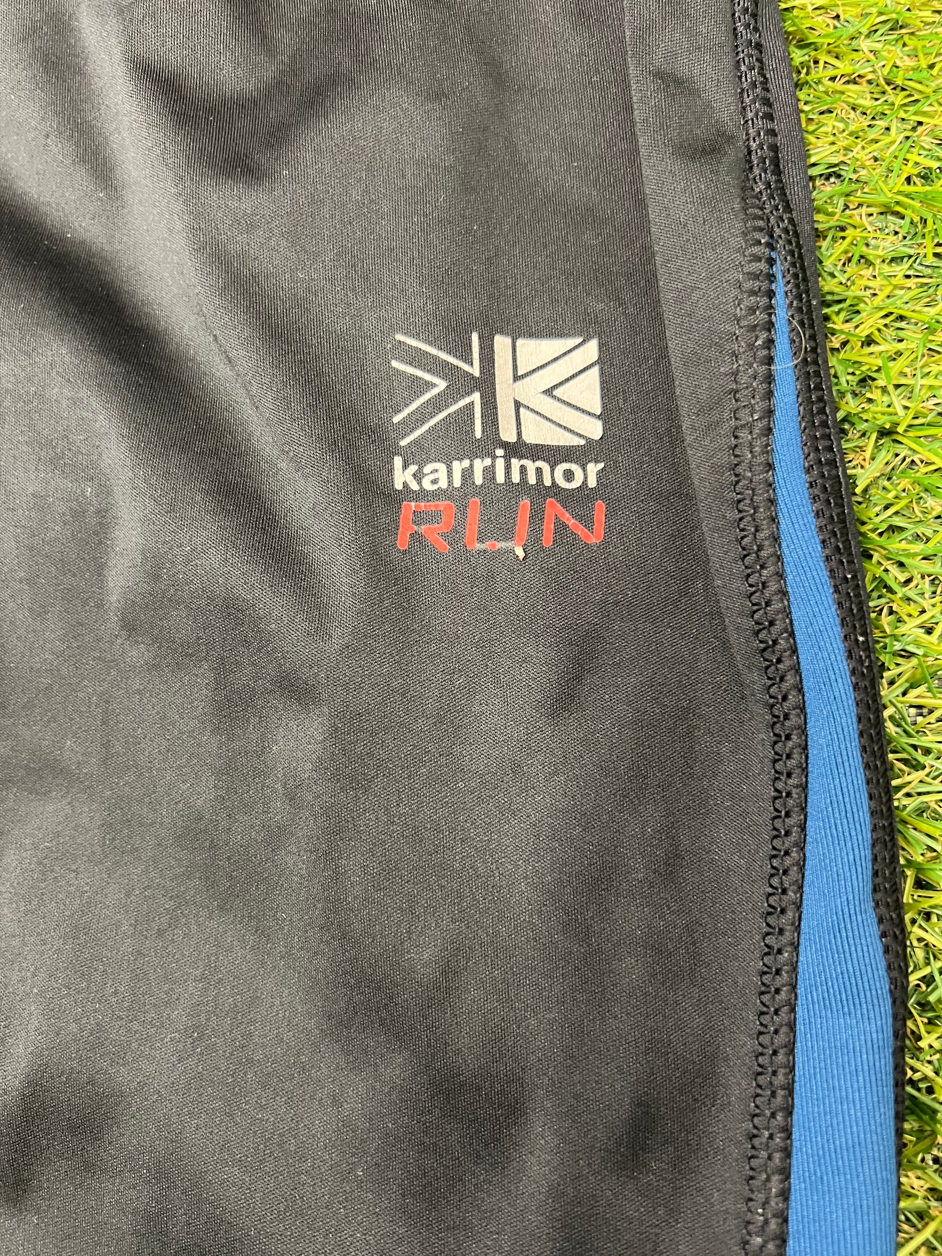 Close-up of Karrimor RUN logo on black fabric with blue panel and neat stitching