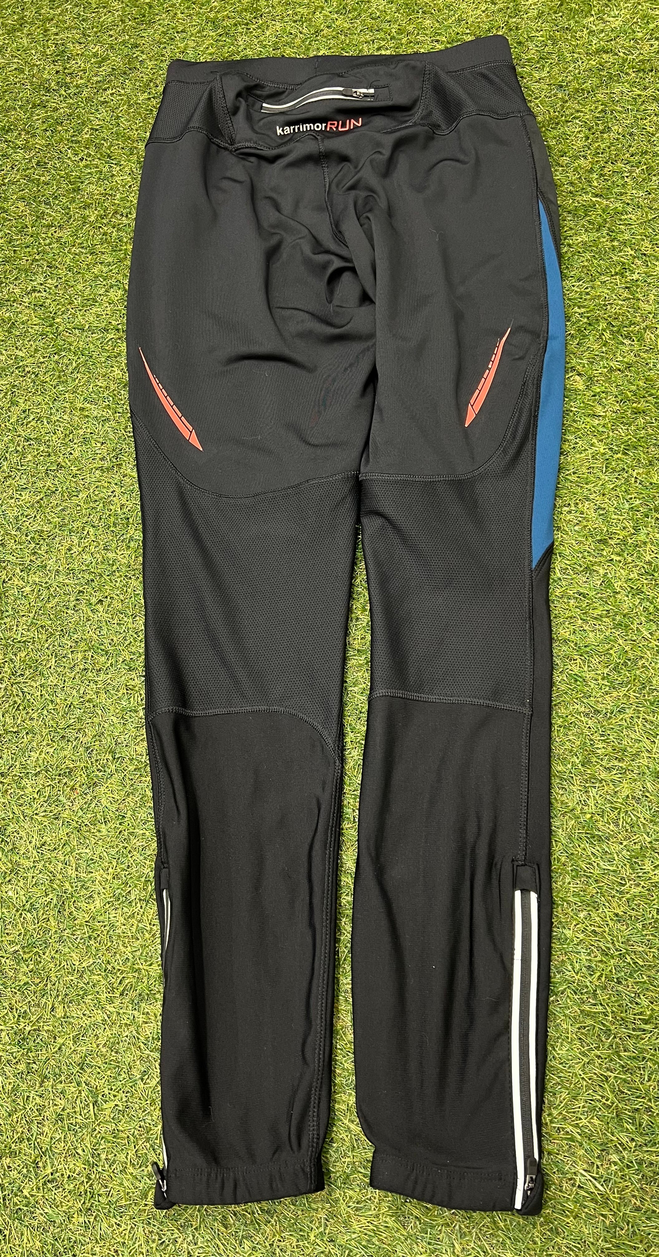 Rear view of black Karrimor running tights showing zippered back pocket and reflective orange stripes on the sides