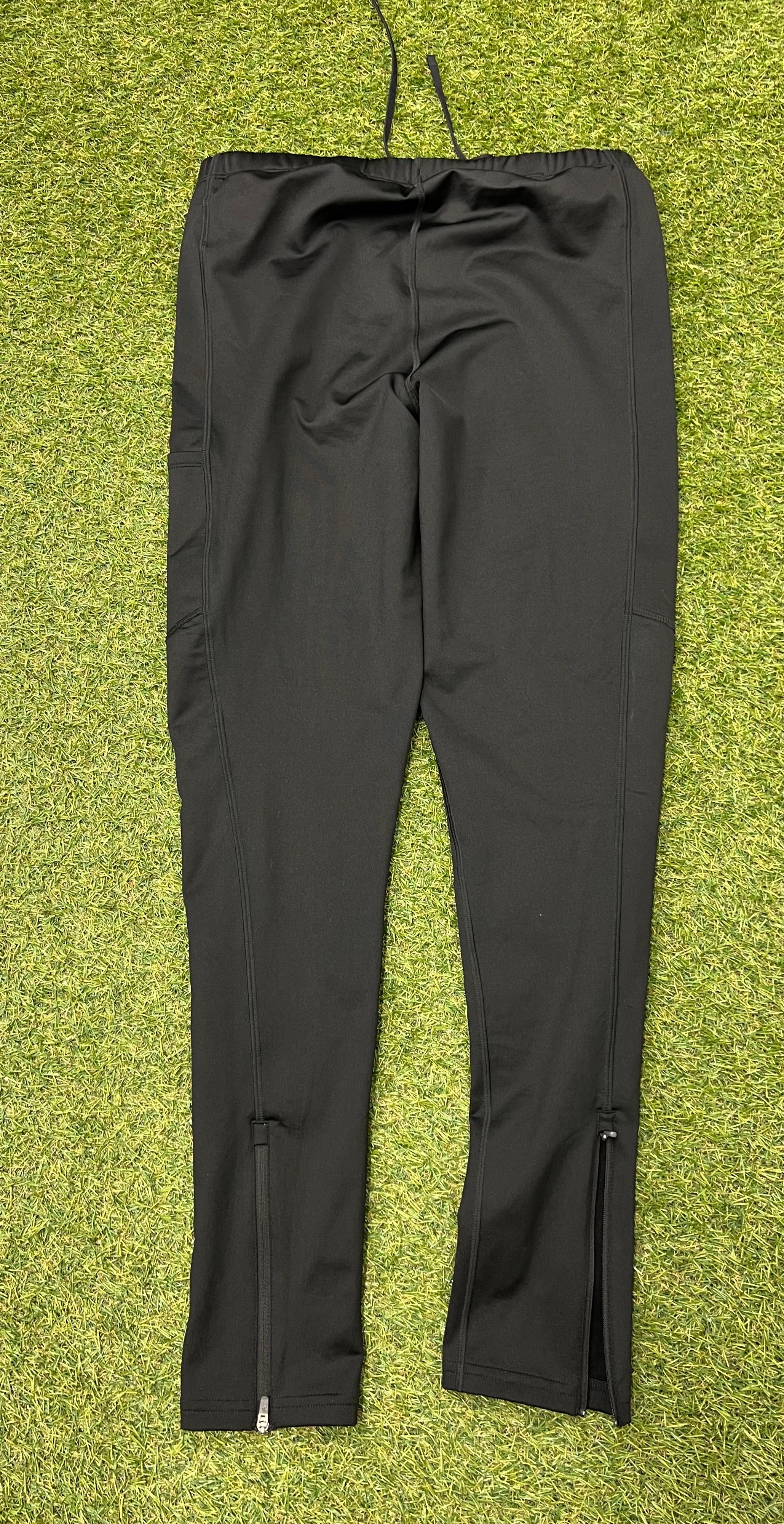 Rear view of black New Balance running trousers showing zipped cuffs at ankles