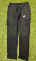 Front view of Adidas black panelled tracksuit bottoms with logo