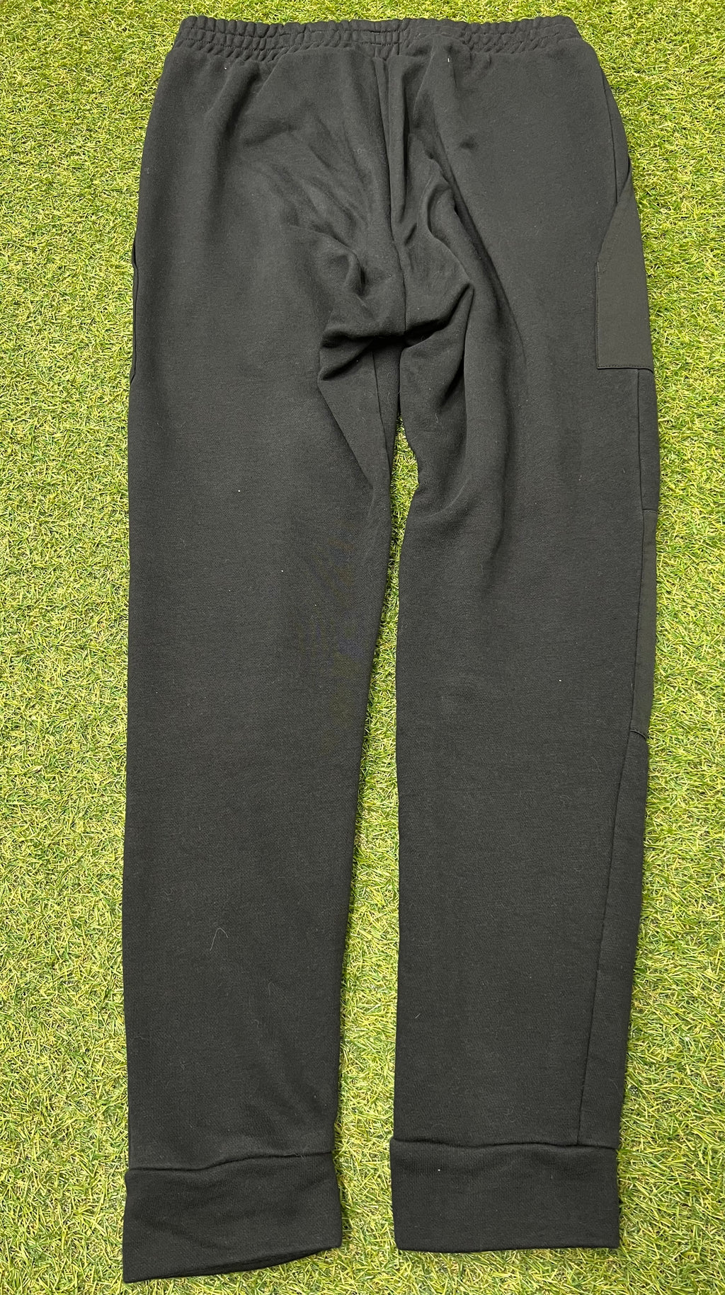 Rear view of Adidas black tracksuit bottoms showing elasticated waistband and ribbed ankle cuffs