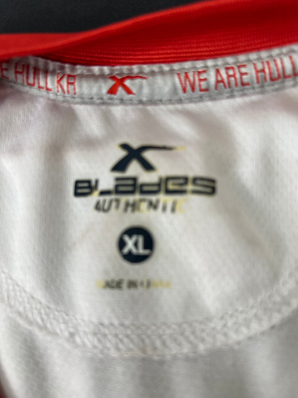 Close-up of X Blades logo, size XL label, and inner neckline detail inside the sleeveless top