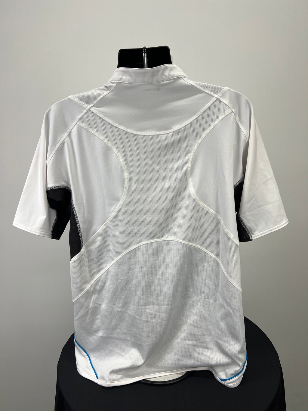 Back view of men's Wilson white tennis top showing mesh ventilated panels and short sleeves on mannequin