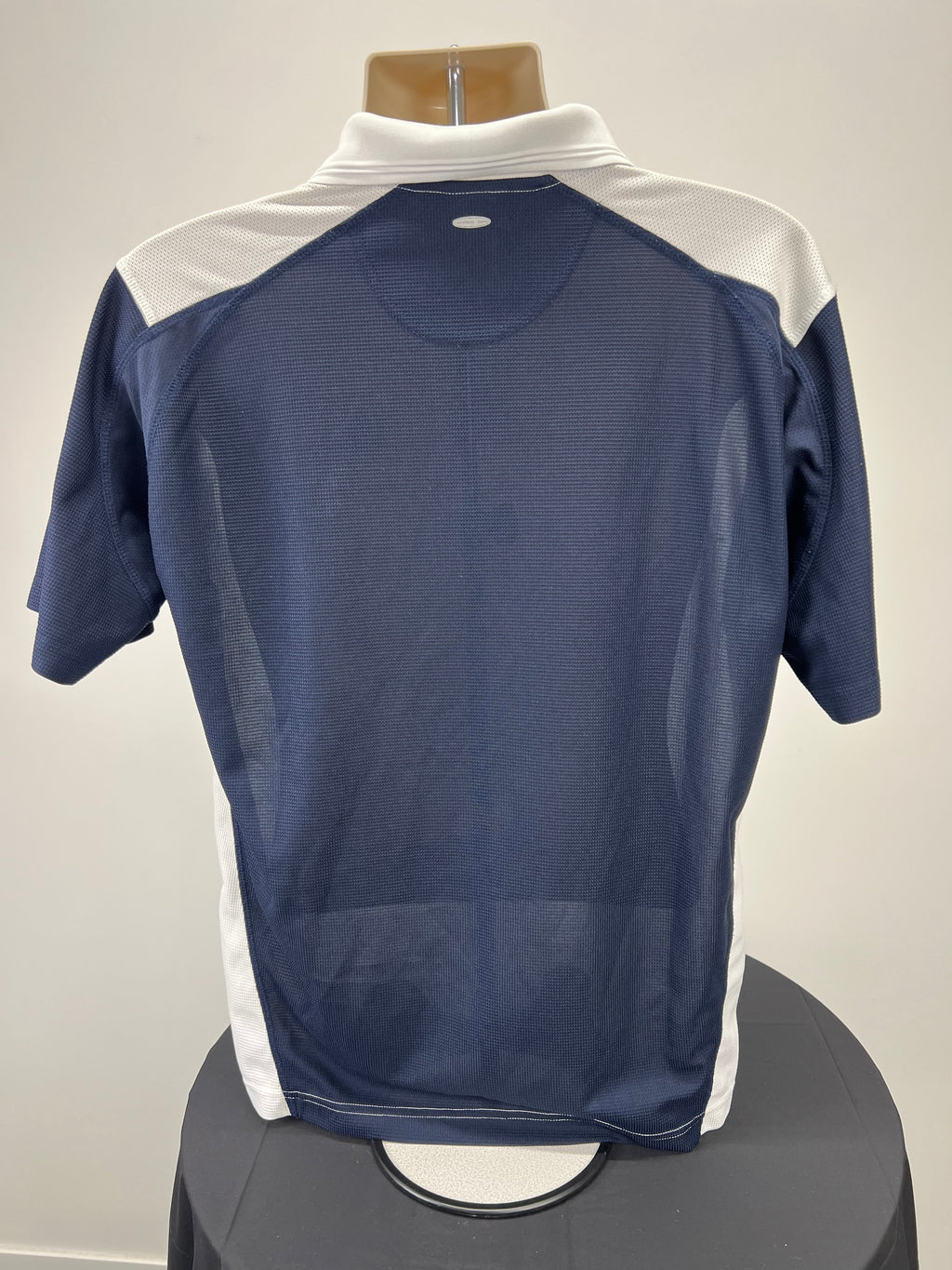 Back view of men's Wilson polo shirt showing navy blue mesh fabric with white sections on shoulders