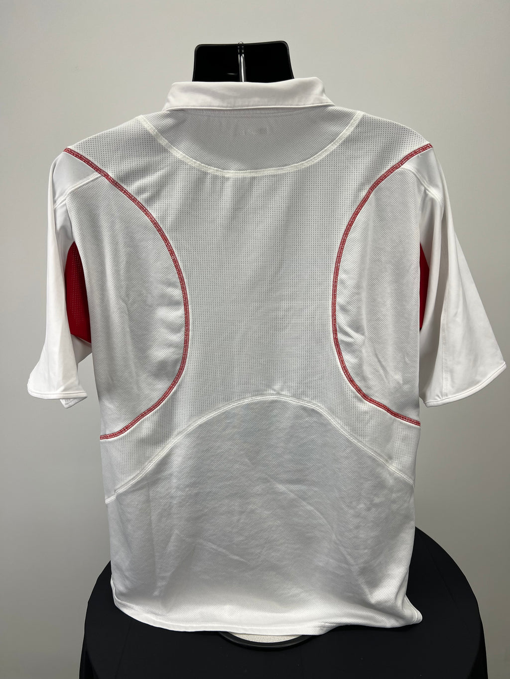 Back view of white Wilson men's polo with red curved details and mesh fabric on mannequin