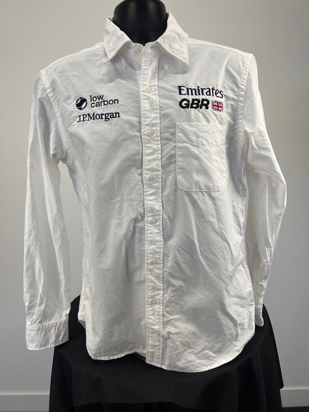 Front view of white long sleeve button-down shirt with Emirates GBR and sponsor embroidery