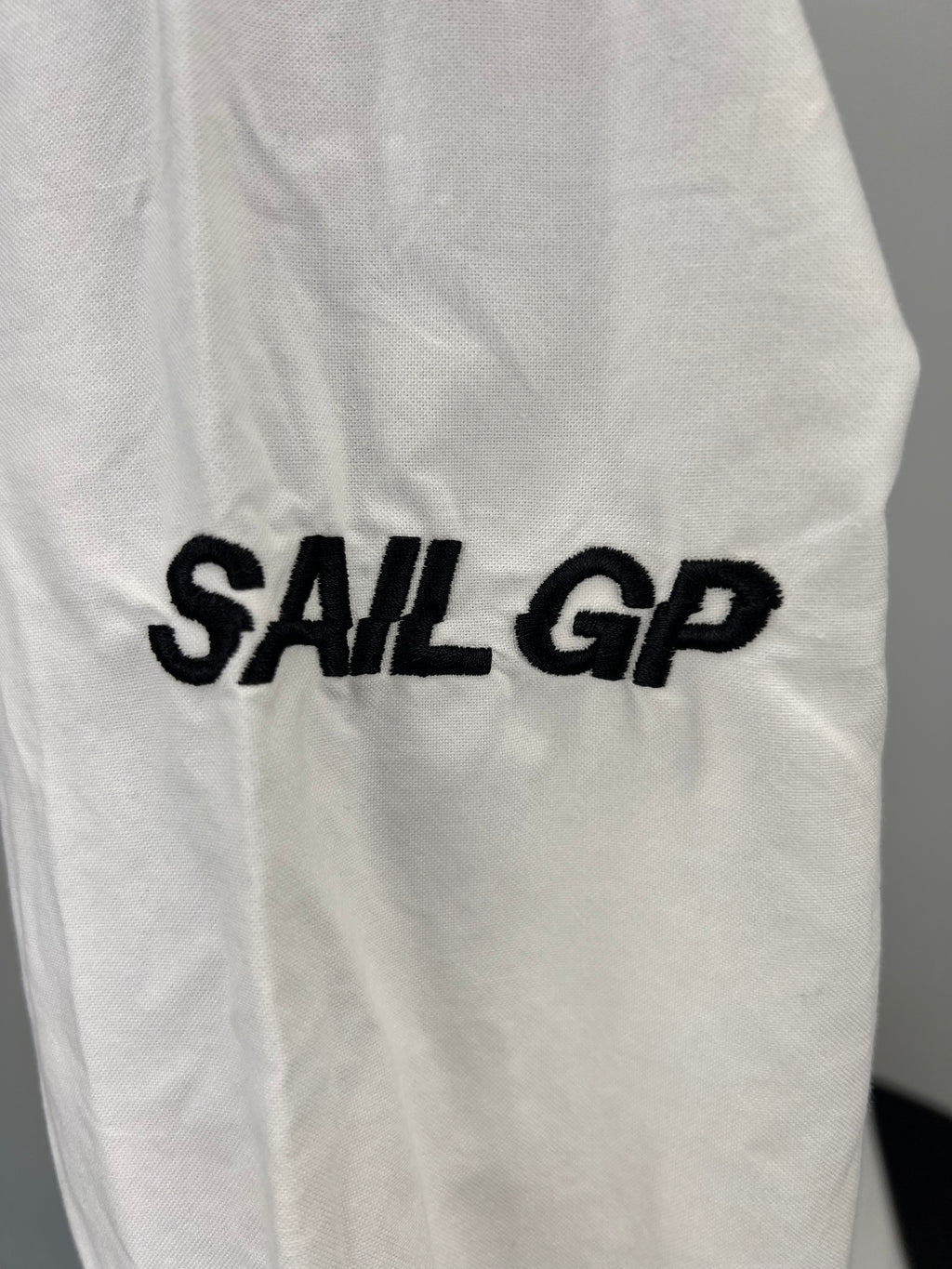 Close-up of Sail GP embroidery on sleeve of white shirt