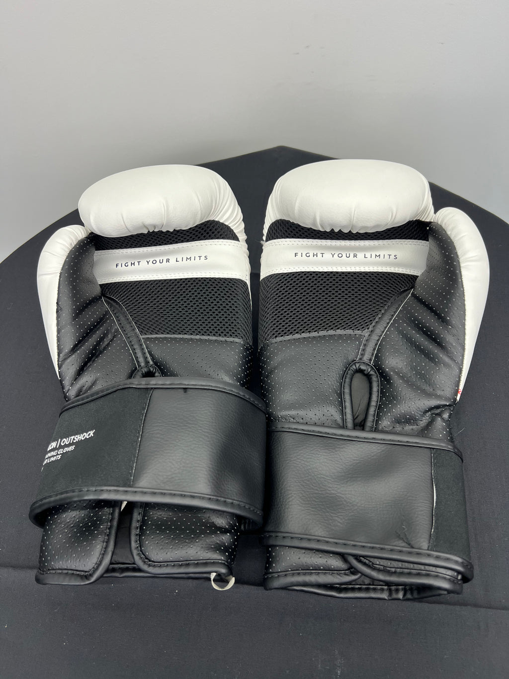 Inside view of TRNG Outshock boxing gloves showing black perforated palm area with Fight Your Limits text