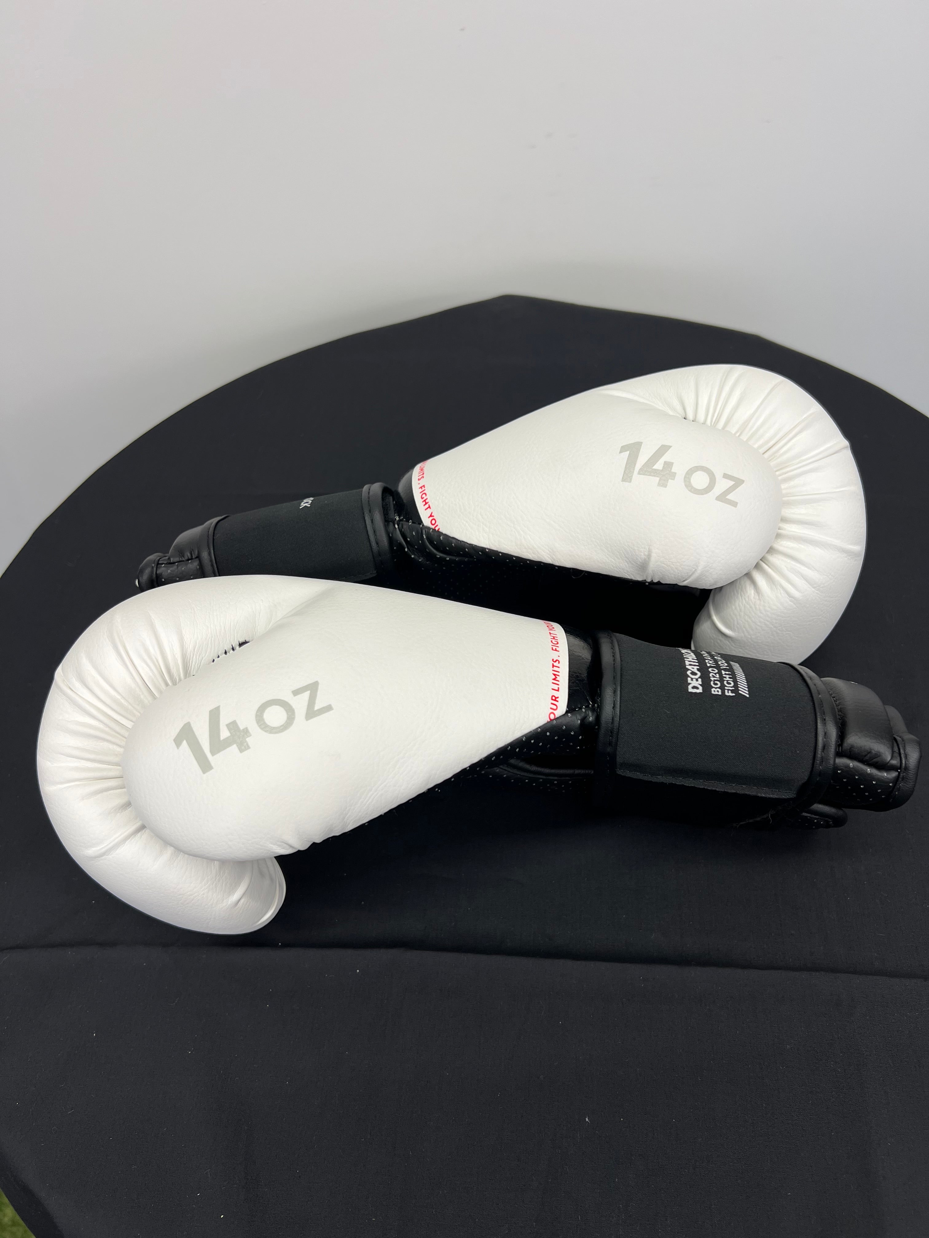 Side view of TRNG Outshock boxing gloves showing curved padded knuckle area and 14oz marking
