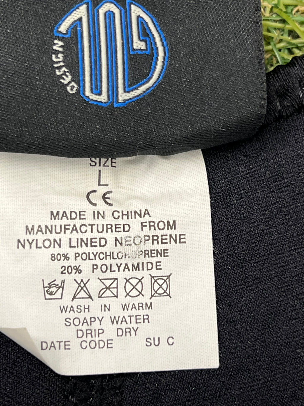 Close-up of size label inside the wetsuit, indicating nylon-lined neoprene material blend and care instructions