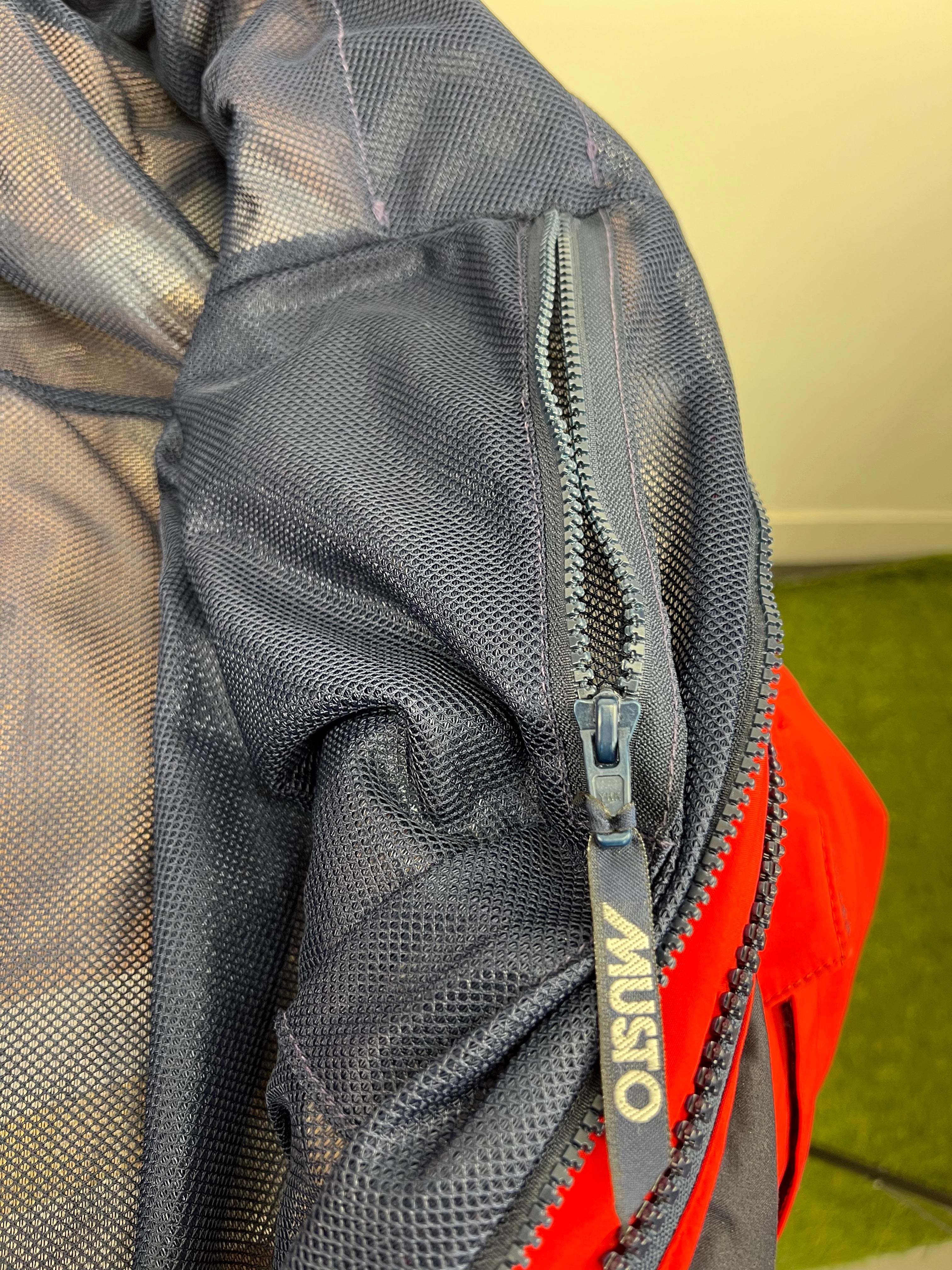 Adjustable yellow hood lining with reflective strip on red sailing jacket