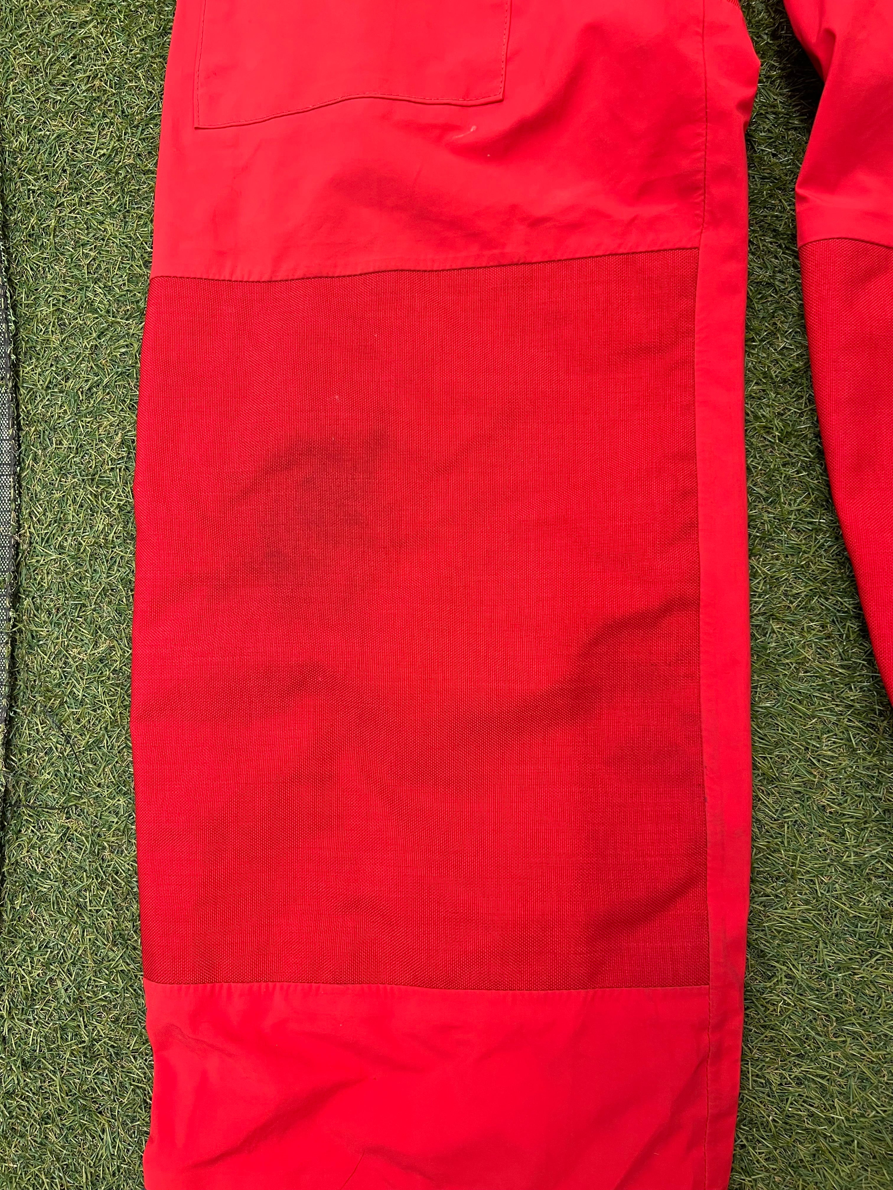 Close-up of red reinforced knee patch on sailing trousers showing sturdy Cordura fabric.