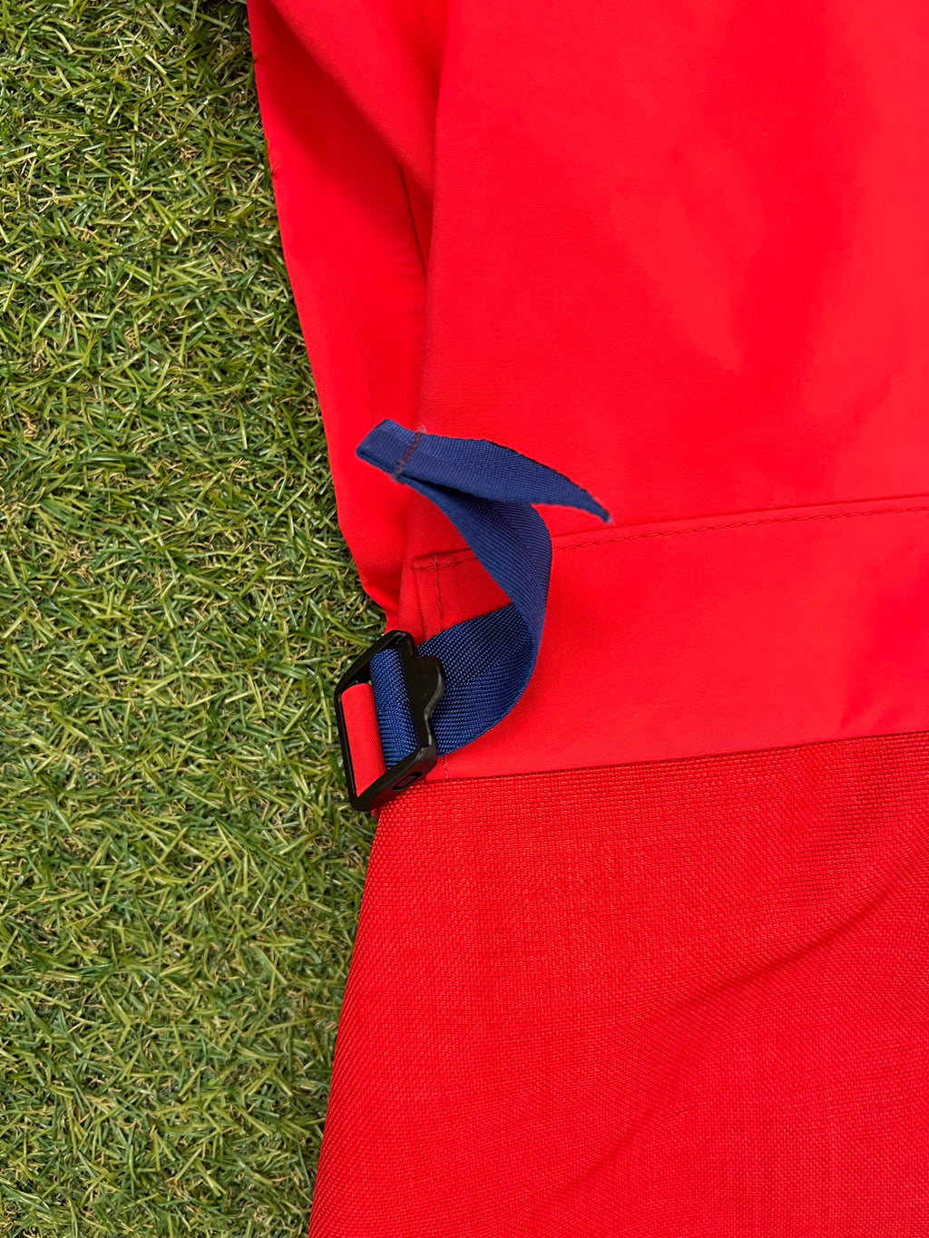 Side close-up showing blue adjustable buckle strap detail on waterproof sailing trousers.