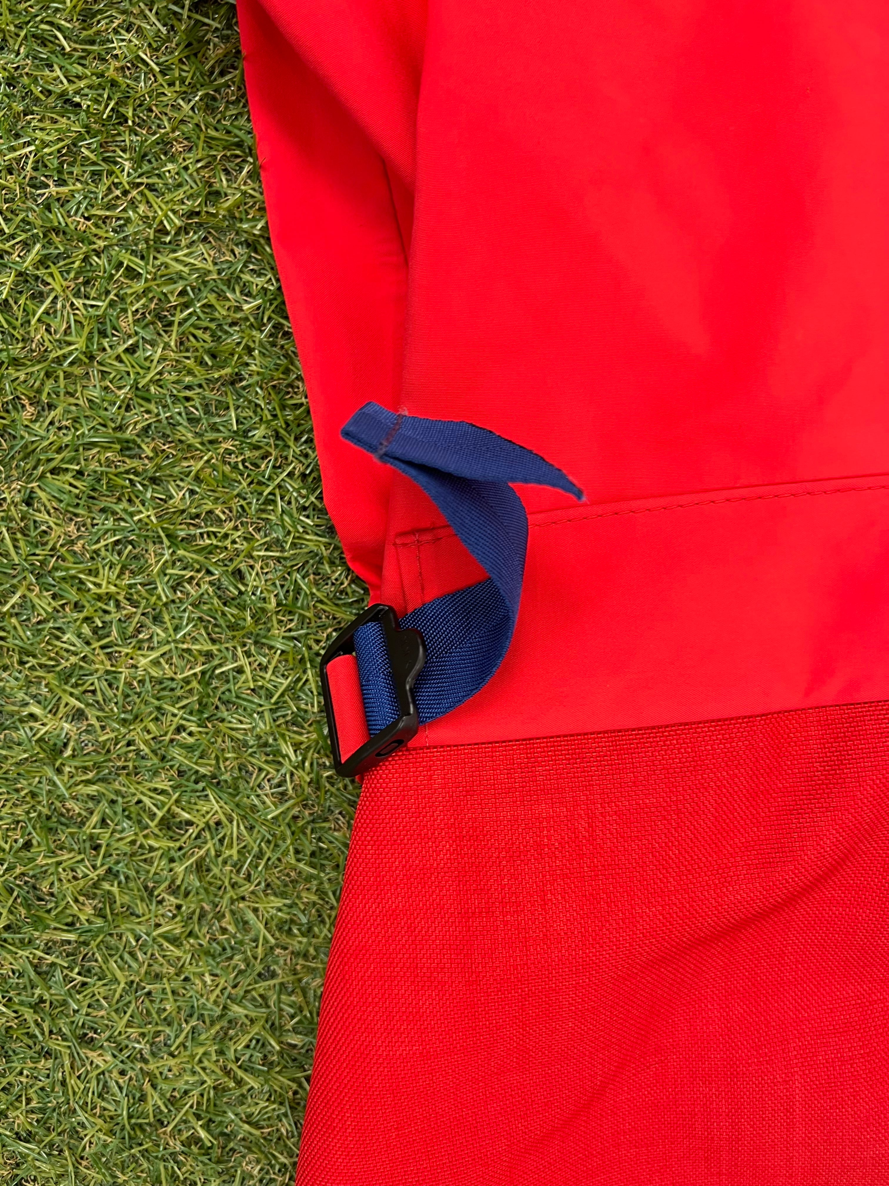 Side close-up showing blue adjustable buckle strap detail on waterproof sailing trousers.