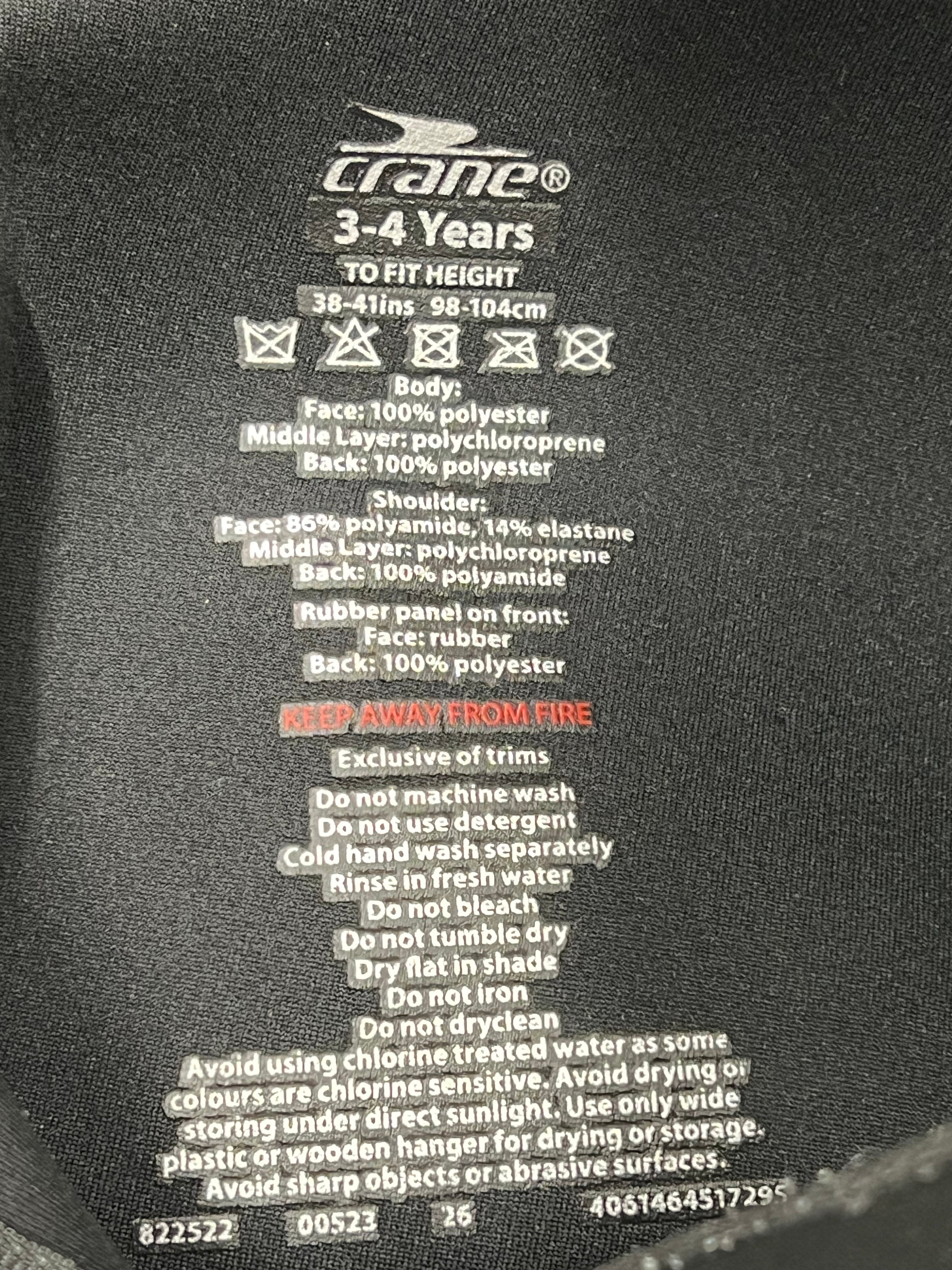 Close-up of inside label detailing materials and care instructions on kids wetsuit