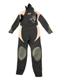 Front view of kids black and pink Sola wetsuit with floral detail and reinforced knee pads on green grass