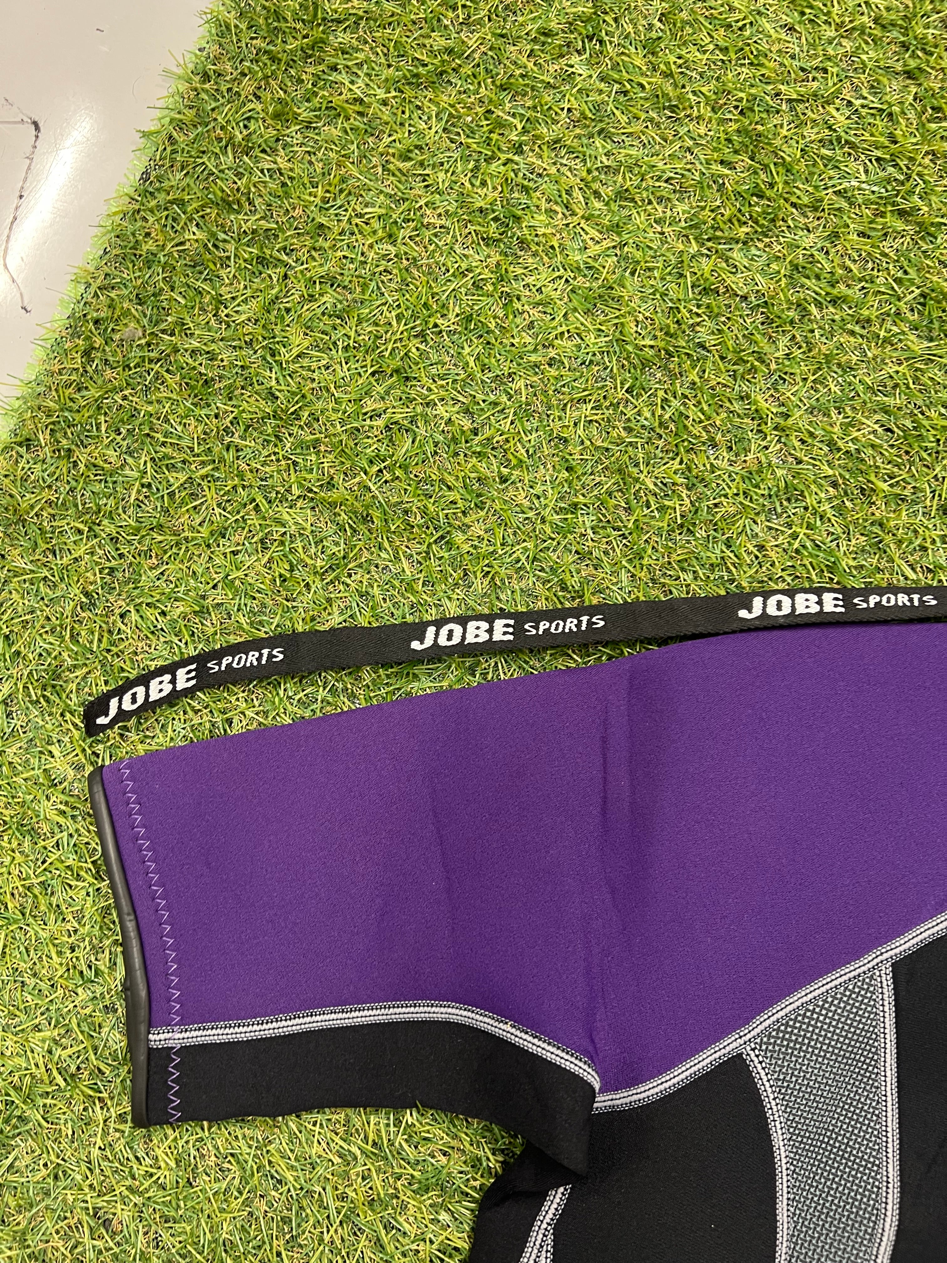 Close-up of purple neoprene sleeve panel with Jobe Sports branded pull cord strap