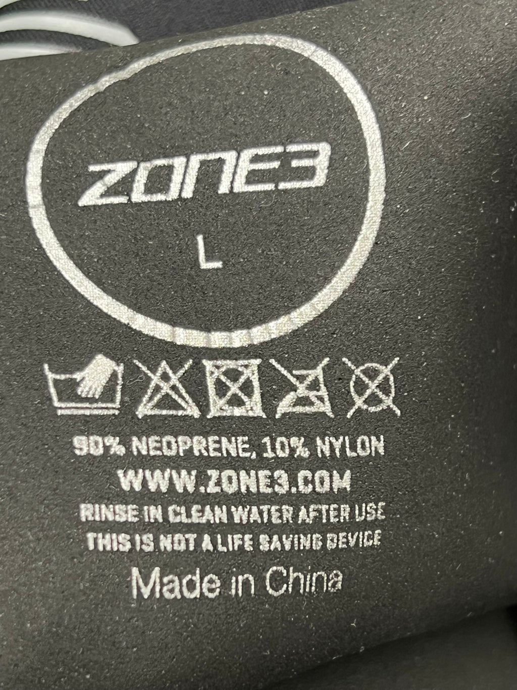 Close-up image of inner label showing Zone3 branding, size L, and material composition of 90% neoprene and 10% nylon