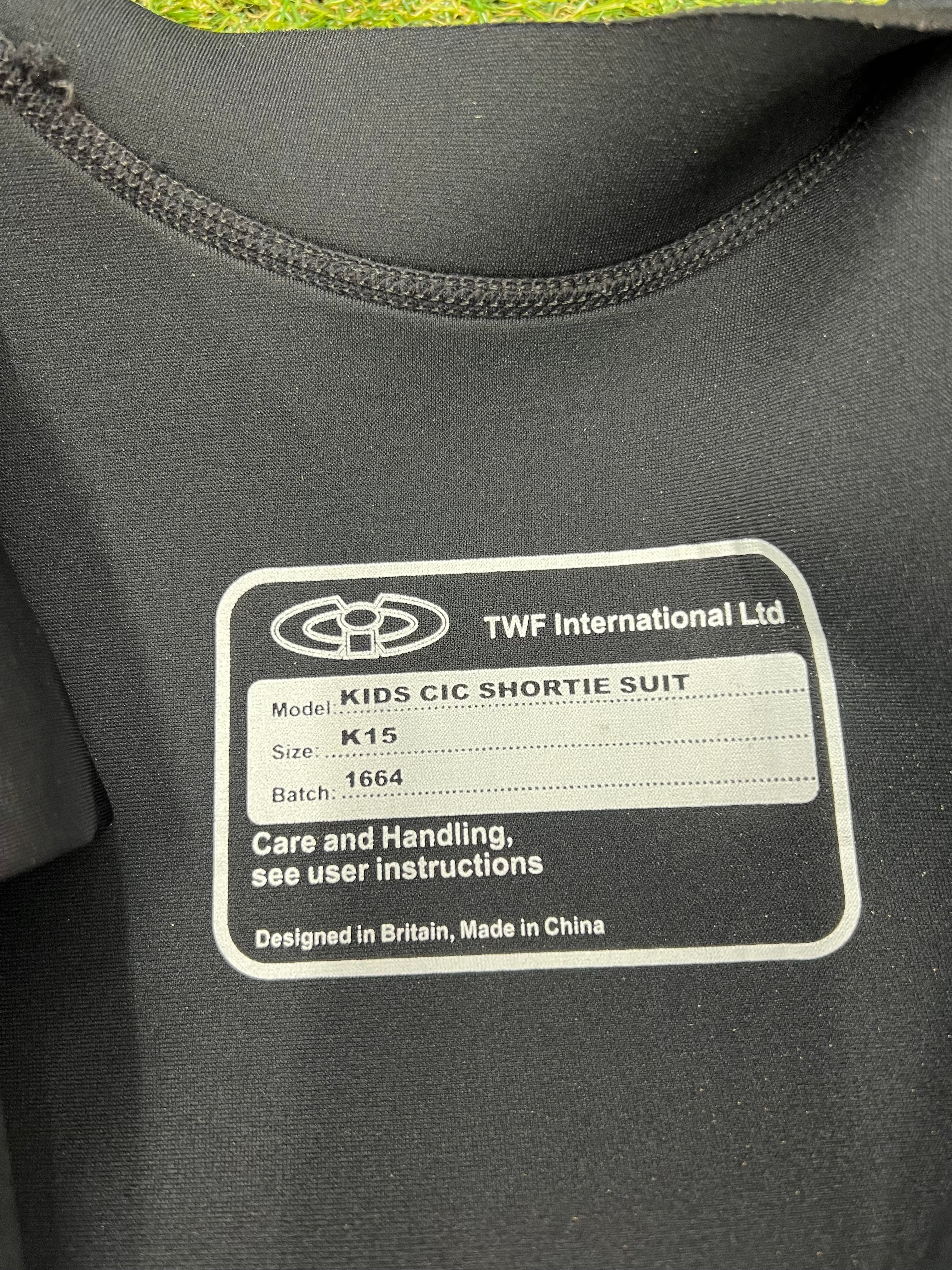 Close-up of inside label of CIC kids shortie wetsuit indicating model K15 and care instructions