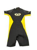 Front view of a black and yellow kids shortie wetsuit laid flat on grass, showing soft neoprene material and short sleeves