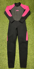 Full length adult wetsuit laid flat on grass with black base and bright pink sleeves and side panels, front view