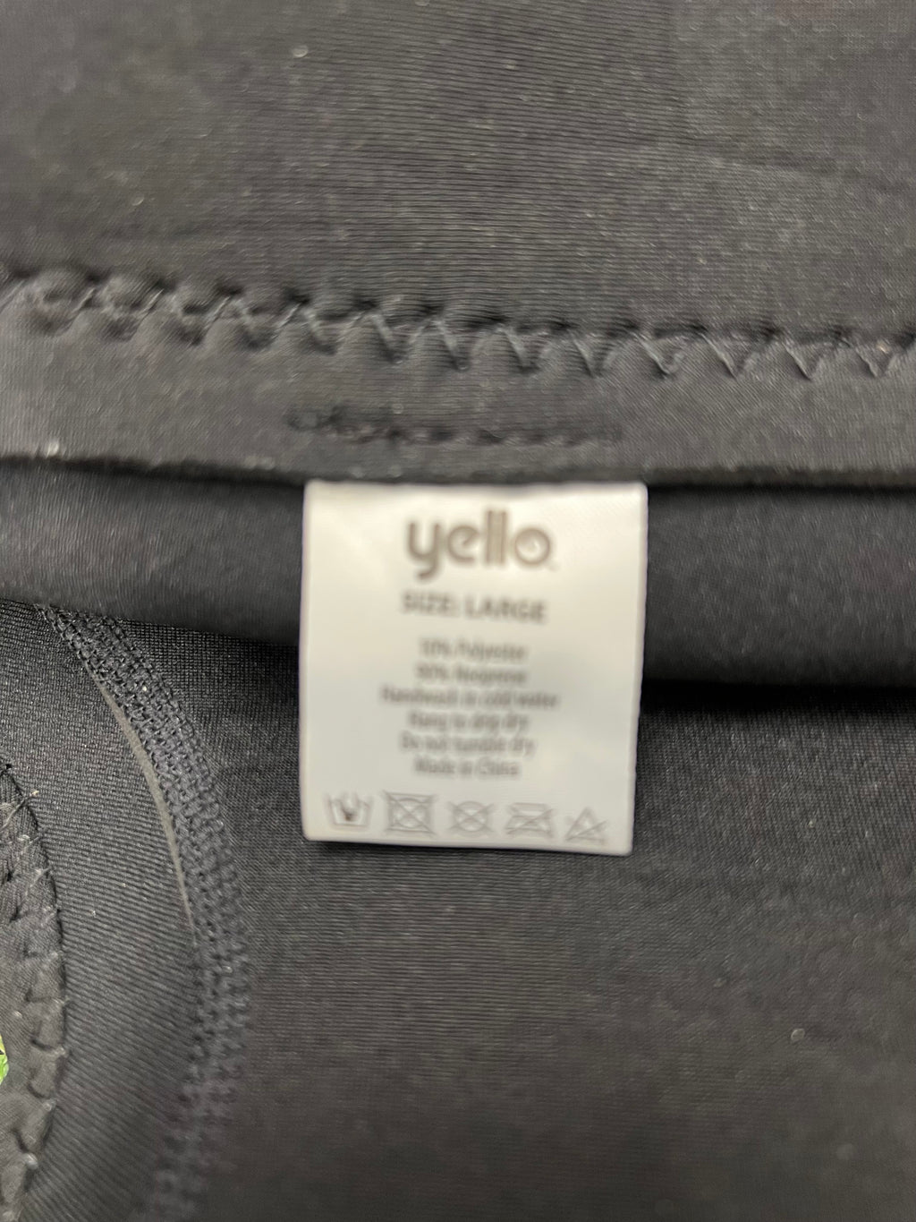 Close-up of the interior label showing wetsuit composition: 10% polyester and 90% neoprene, size large