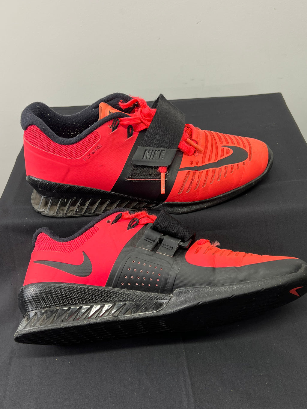 Side view of Nike Romaleos 3 weightlifting shoes displaying the Flywire design and sole structure with adjustable strap engaged