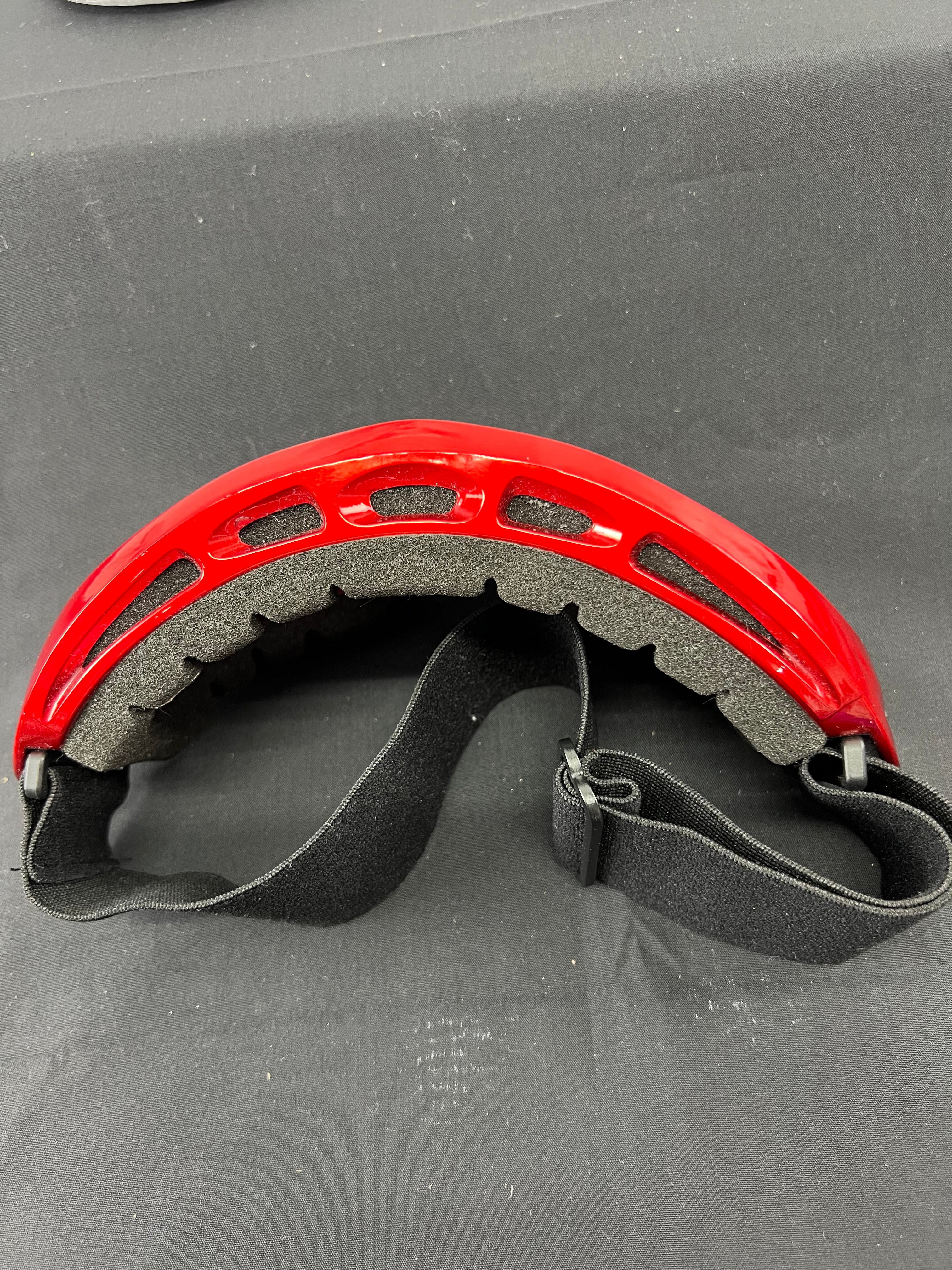 Red ski goggles viewed from above showing interior foam padding and adjustable strap