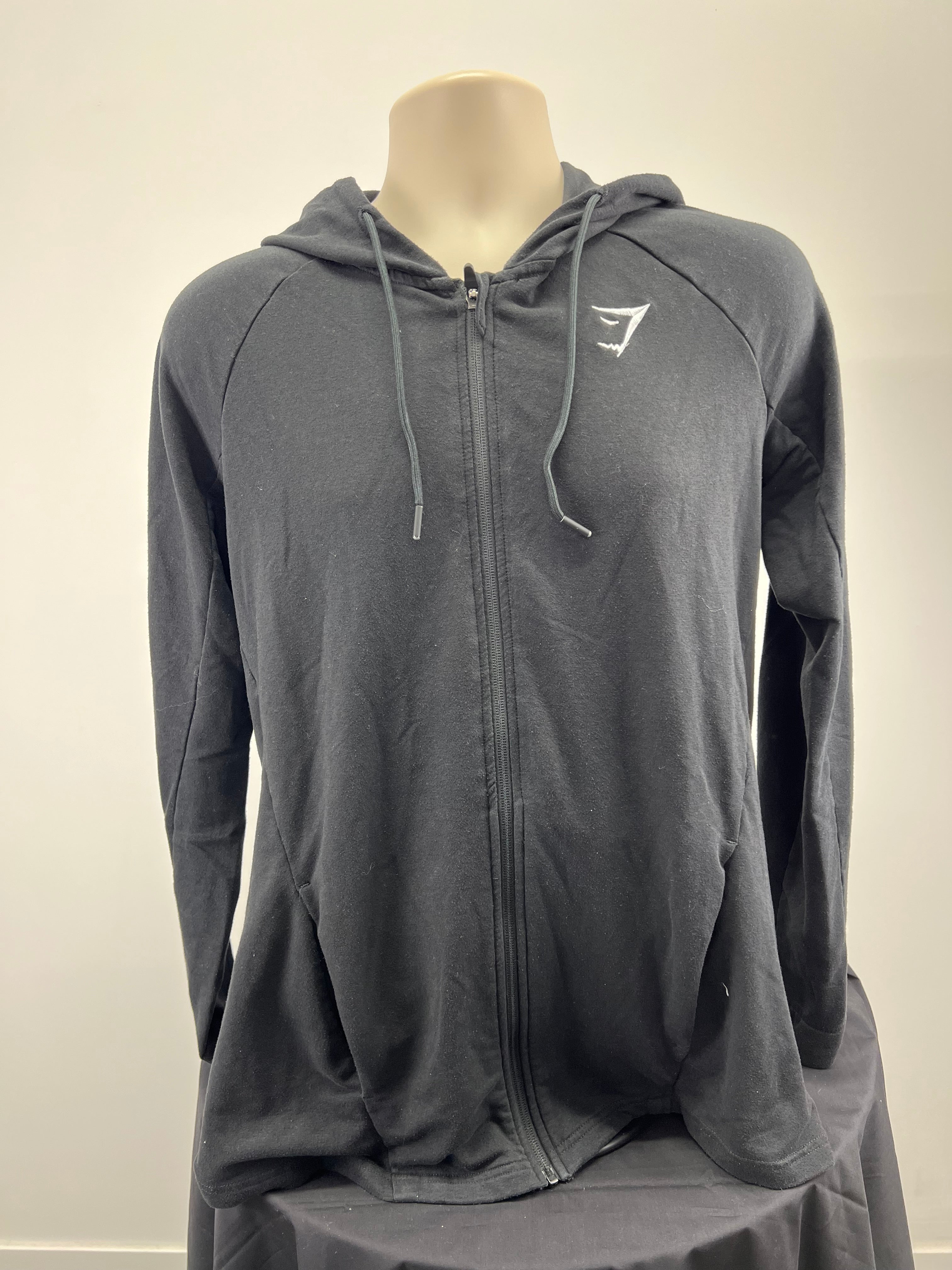 Front view of a men’s black Gymshark full zip hoodie with hood and drawstrings on display
