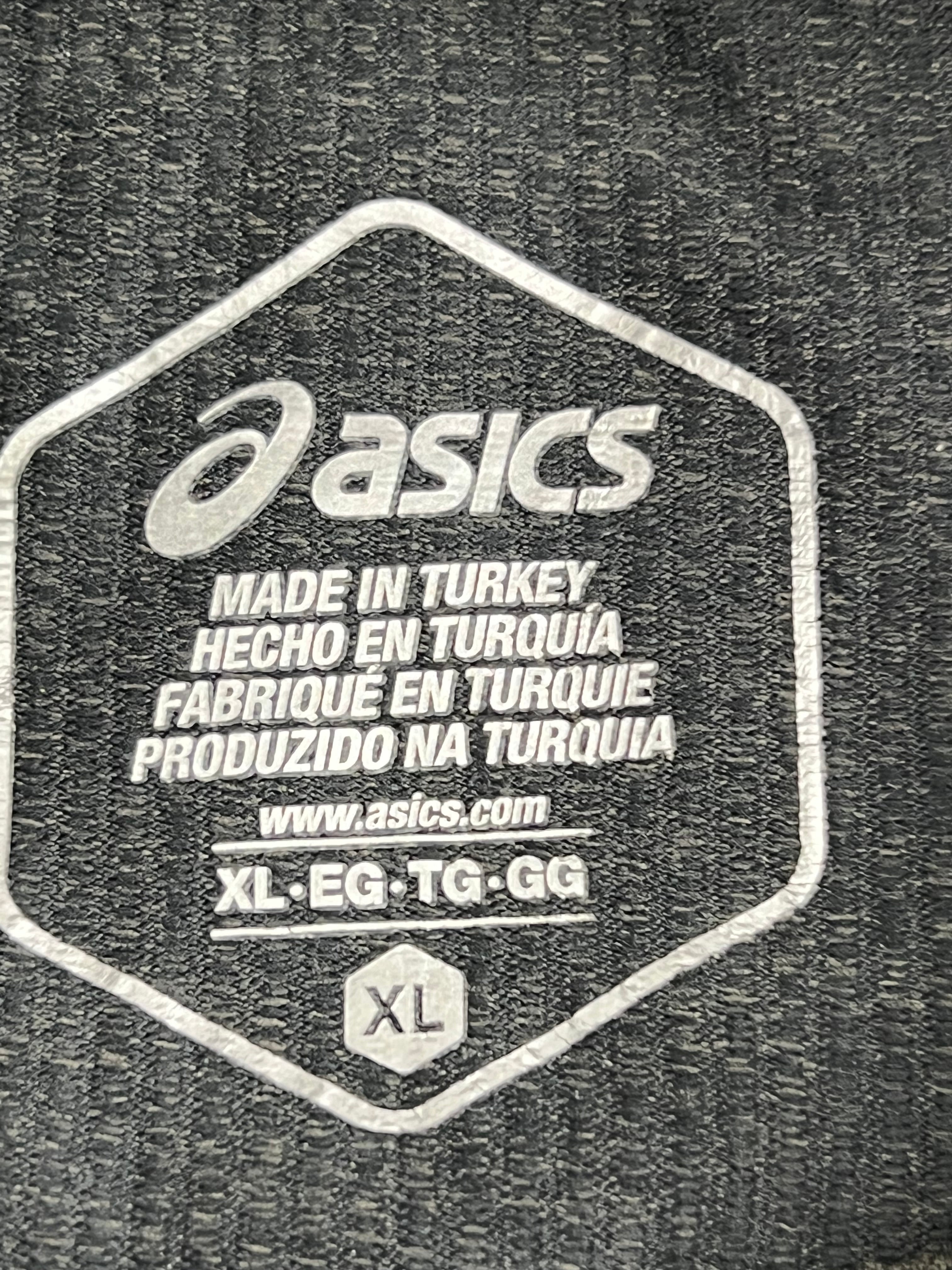 Close-up of Asics brand logo and size label printed inside men's grey long sleeve top