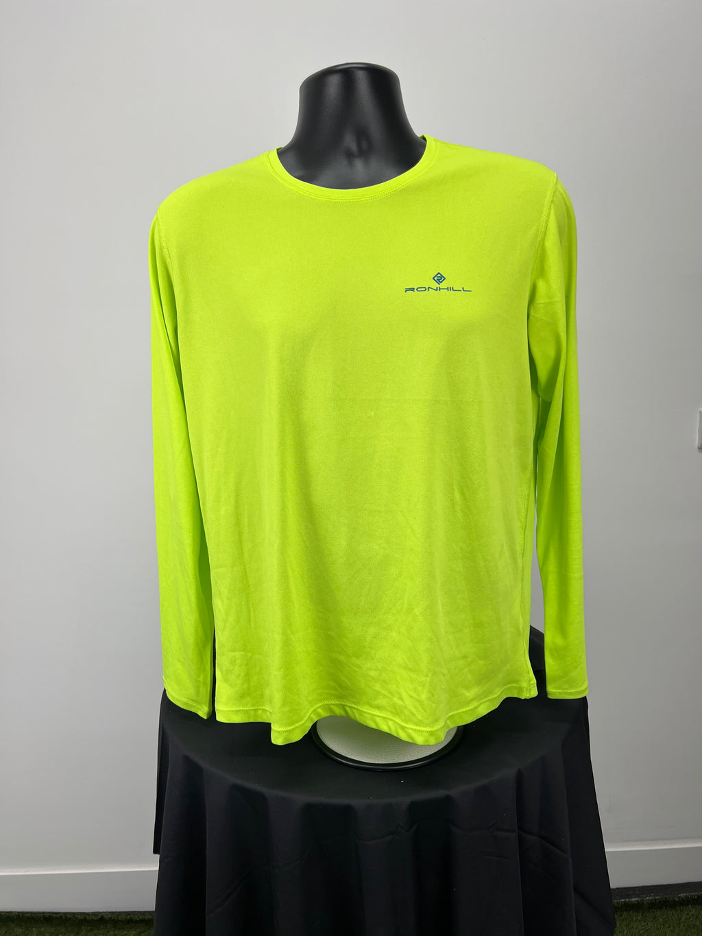 Front view of neon yellow Ronhill long sleeve running top on mannequin