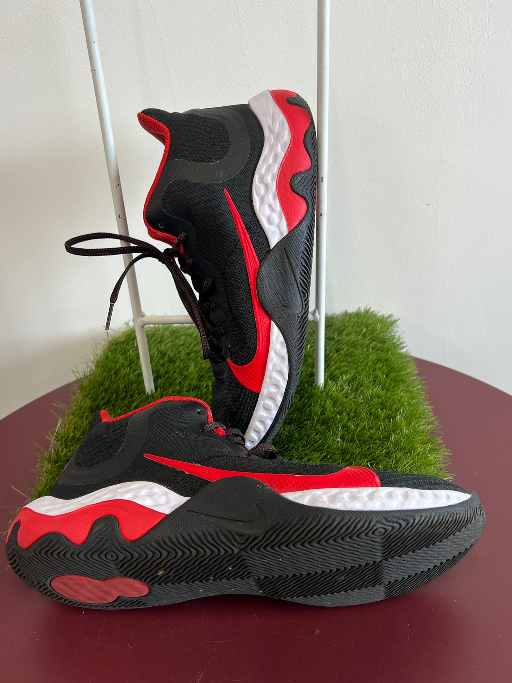 Side profile of Nike Renew Elevate basketball shoes highlighting red swoosh logo and cushioned midsole