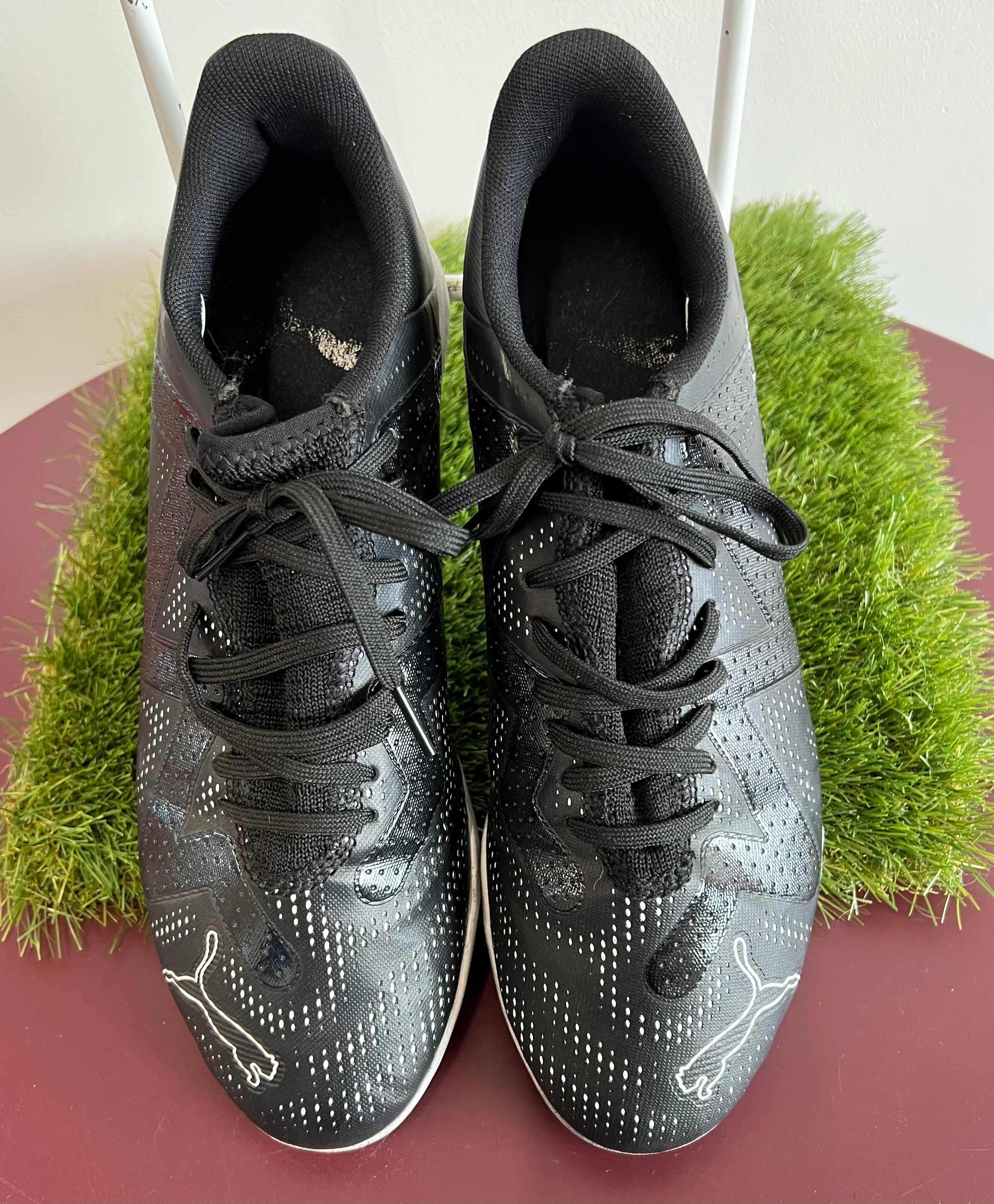 Top view of black Puma FR2 men's turf trainers with perforated upper and Puma logo on toes