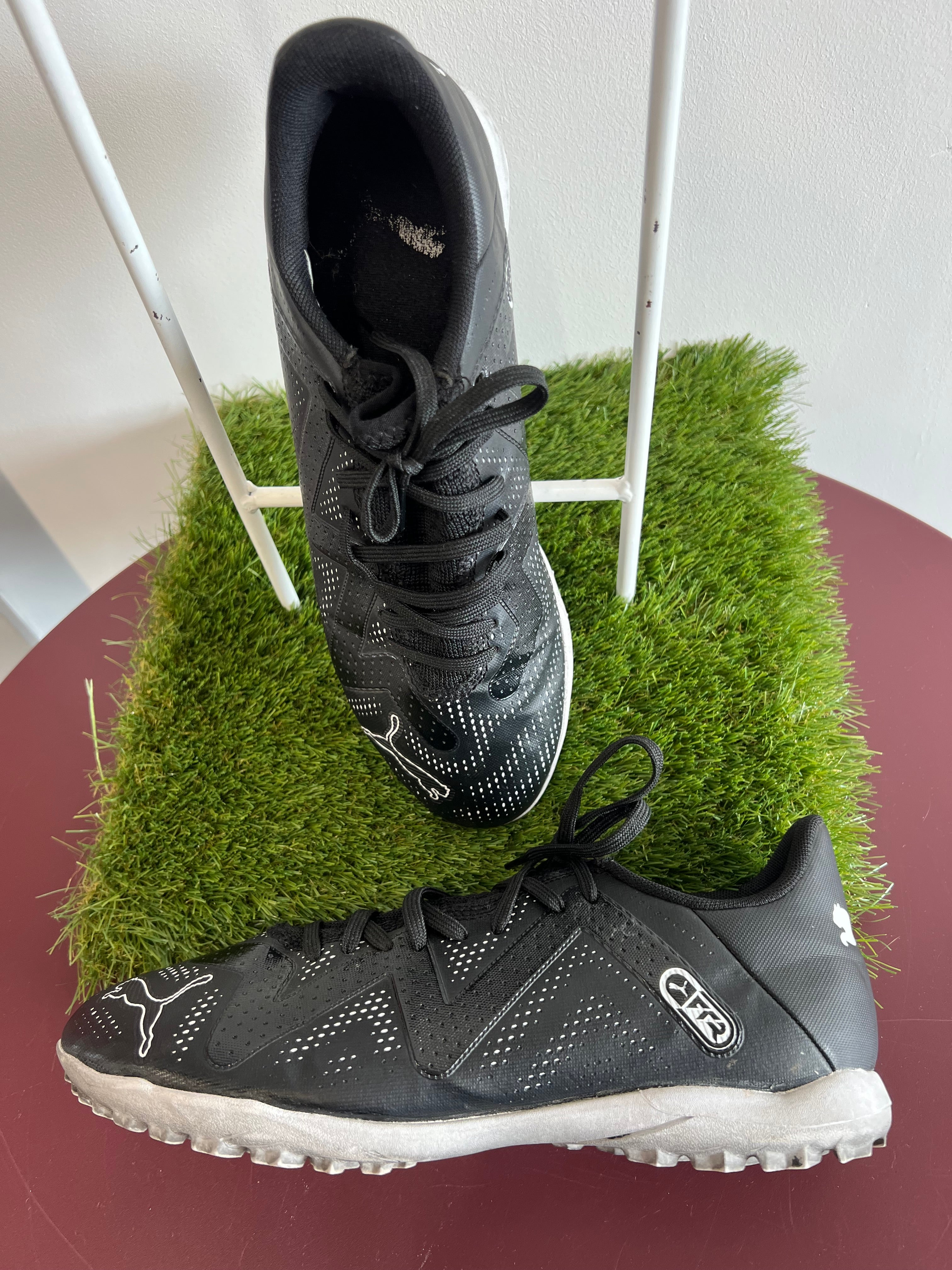 Angled side view of Puma FR2 trainers highlighting sleek black upper and cushioned sole
