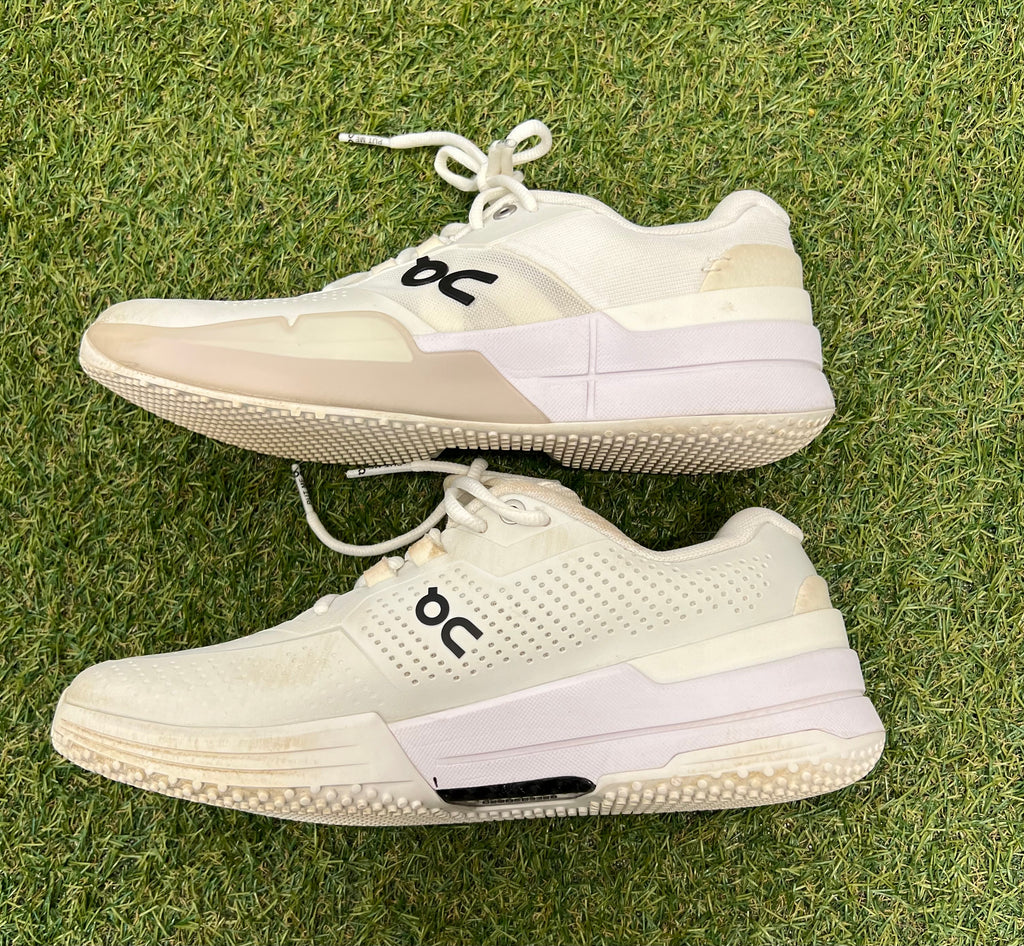 Opposite side profile showcasing logo print and breathable upper on white performance trainers