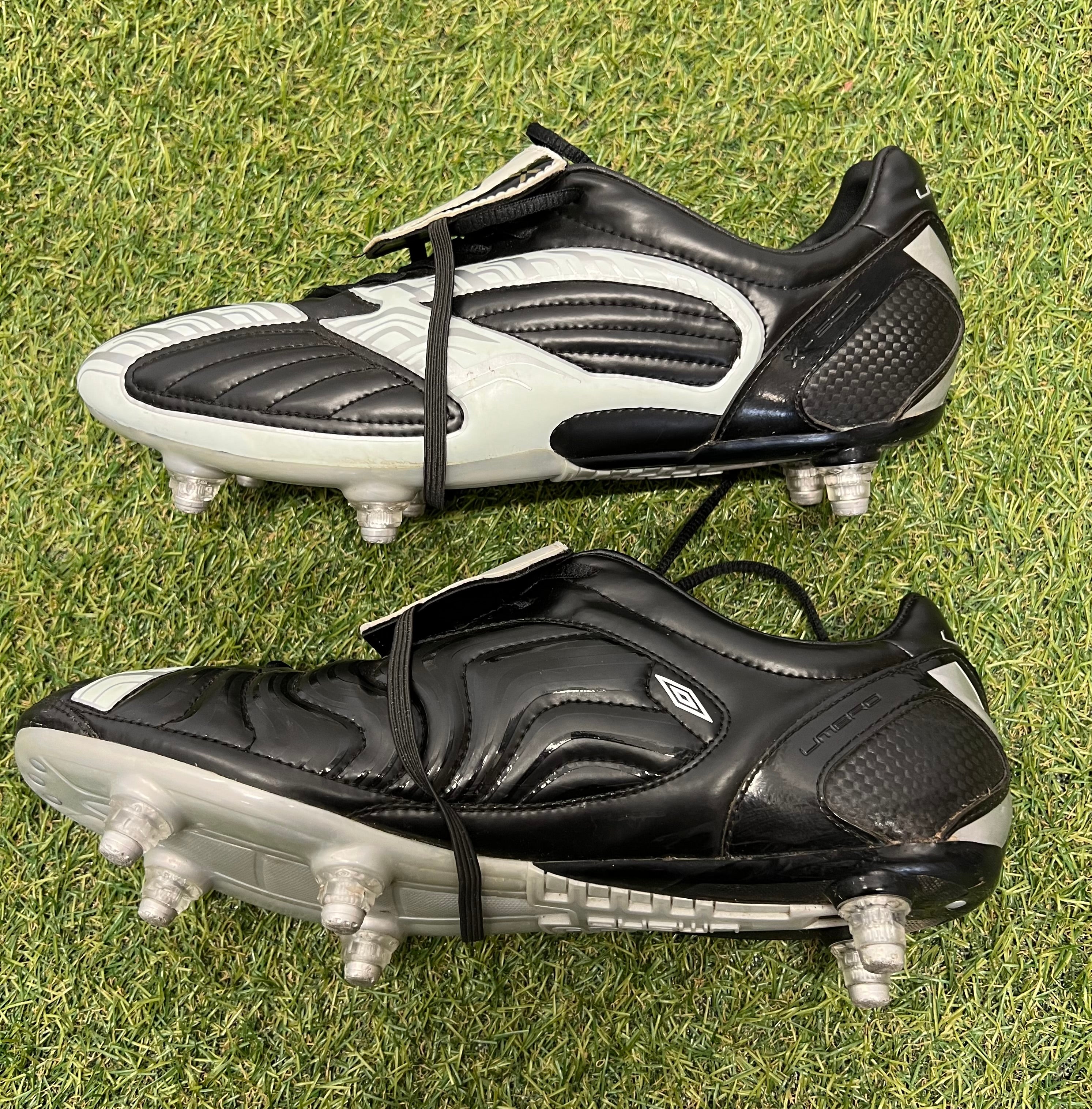 Opposite side view of Umbro football boots showcasing smooth synthetic leather finish and sole studs