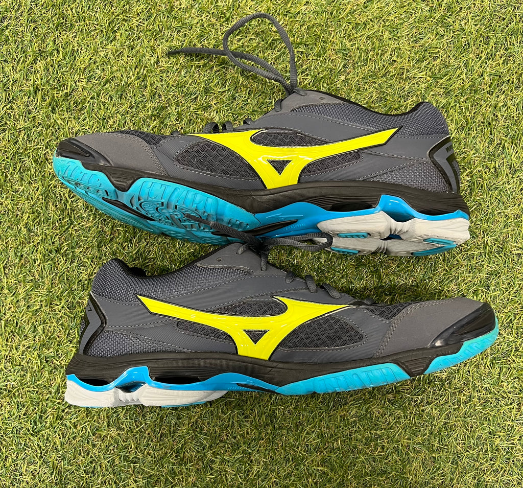 Side profile of Mizuno Wave Bolt 7 trainers displaying grey and yellow design with blue sole cushioning